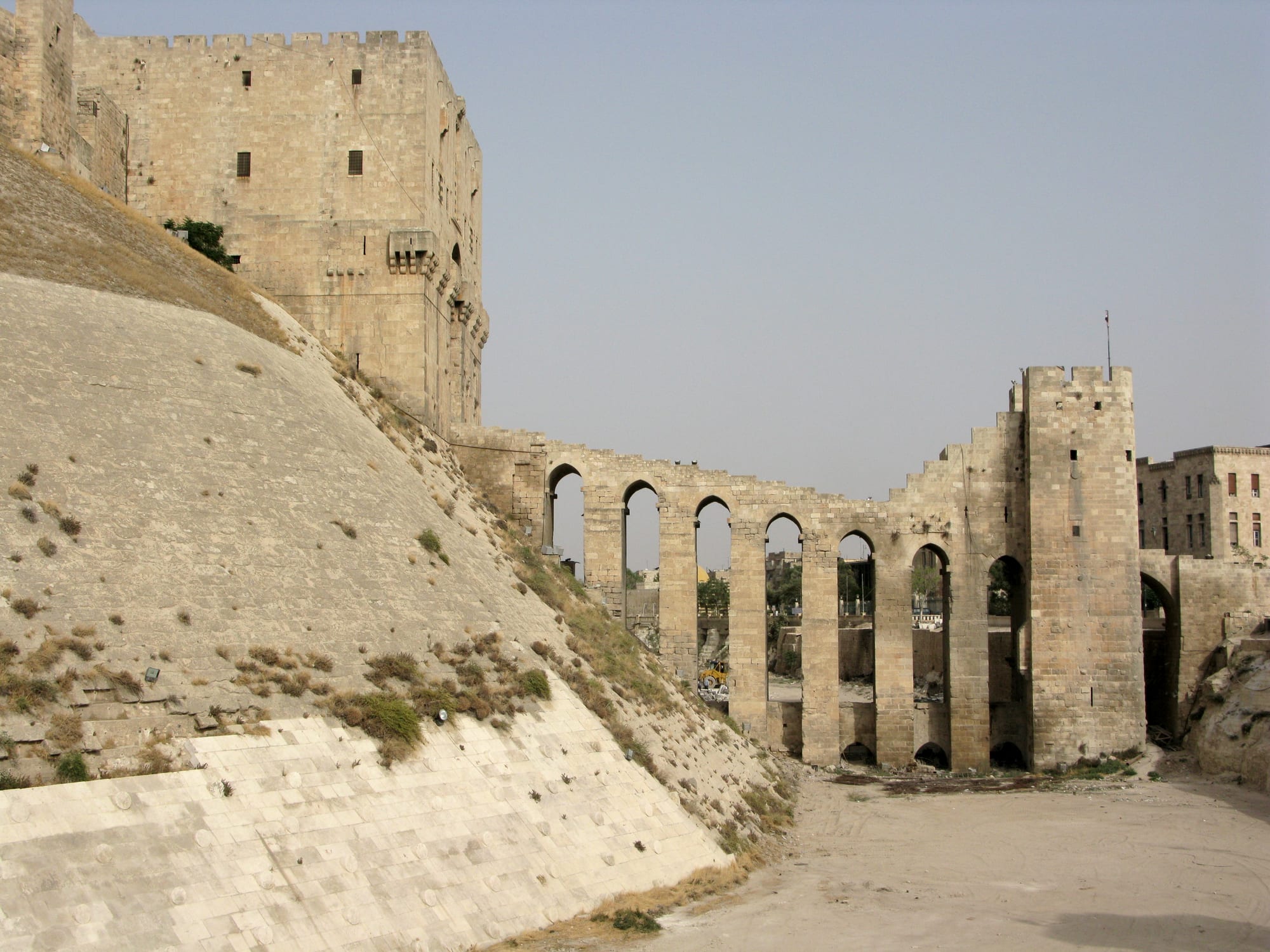 A massive fortified citadel on a raised mound above a city
