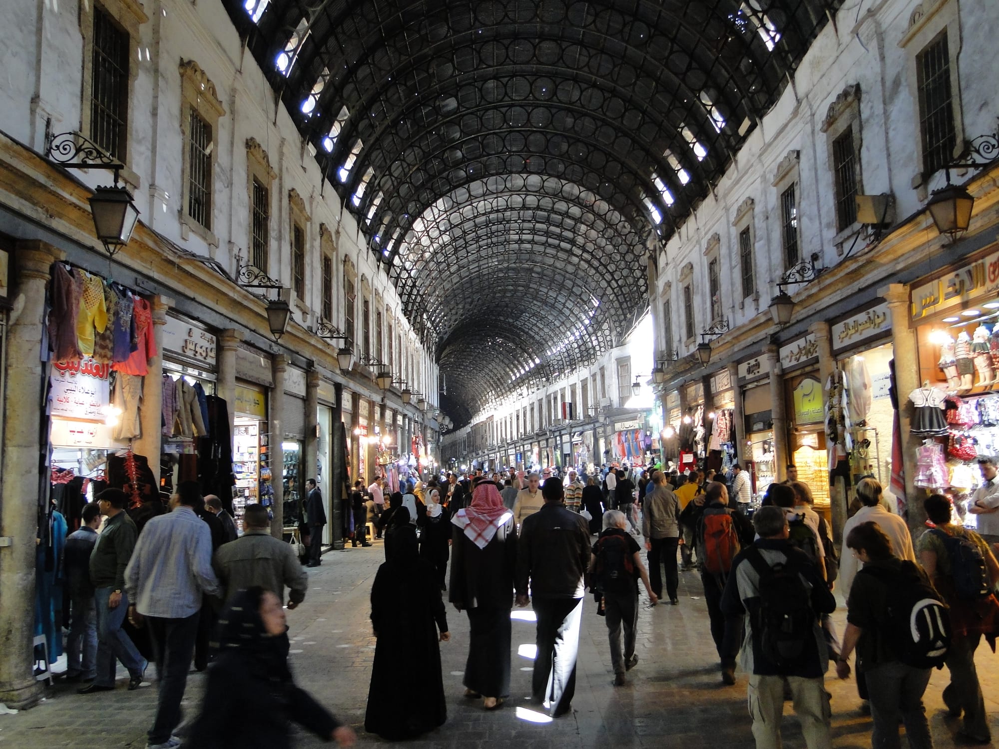 A busy covered market street lined with shops