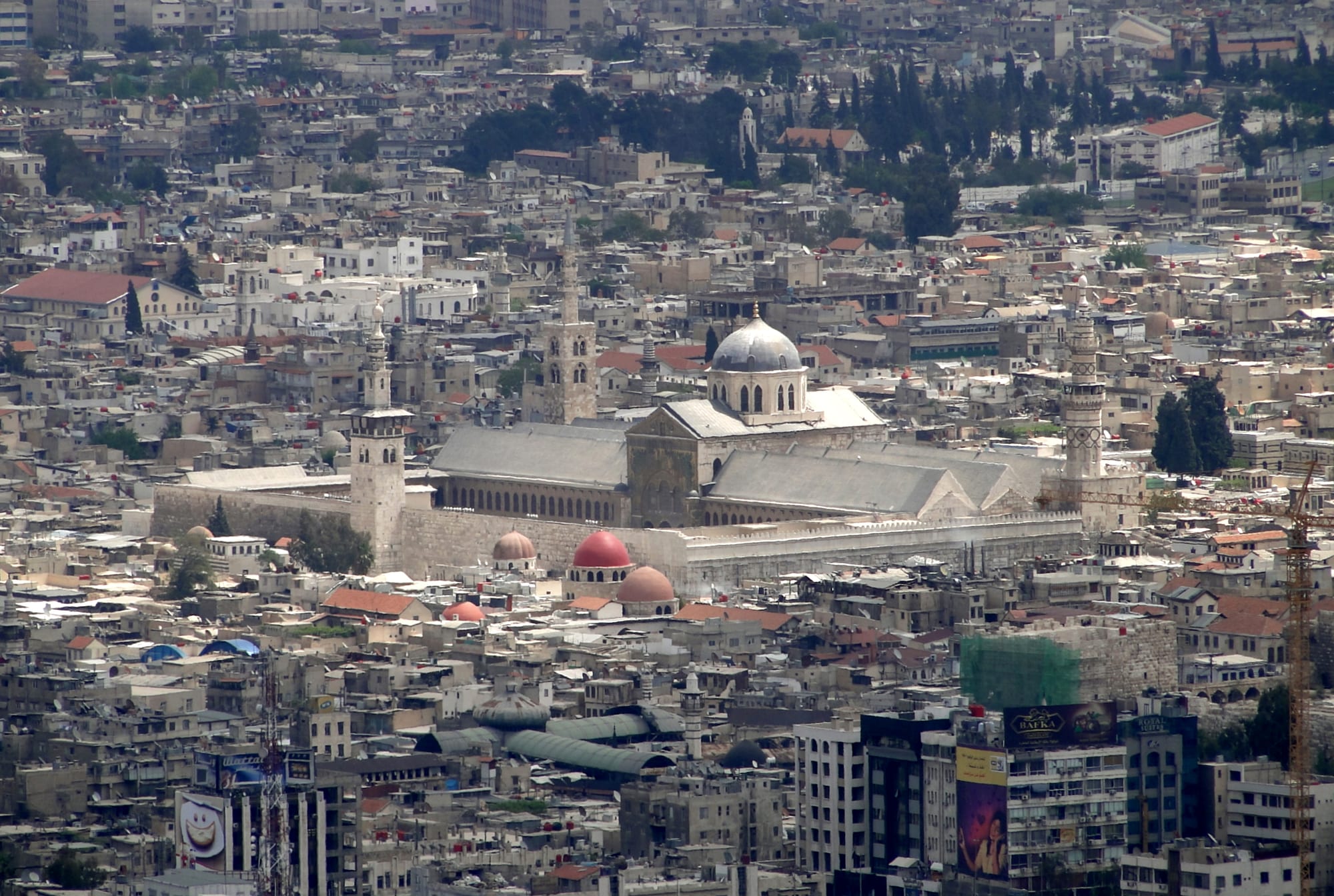 A grand mosque courtyard with a golden-domed shrine and tall minaret