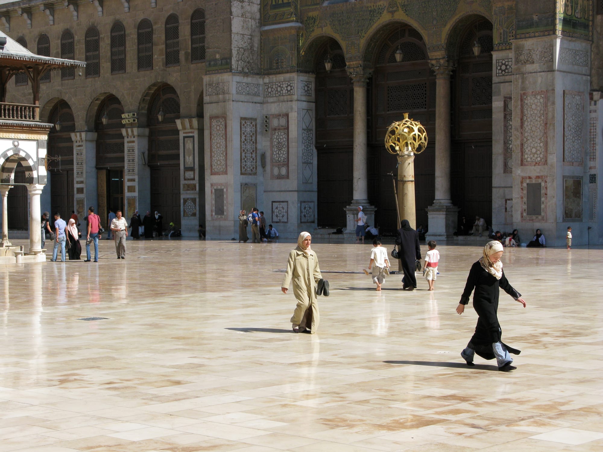 An ornate mosque courtyard decorated with gold mosaics