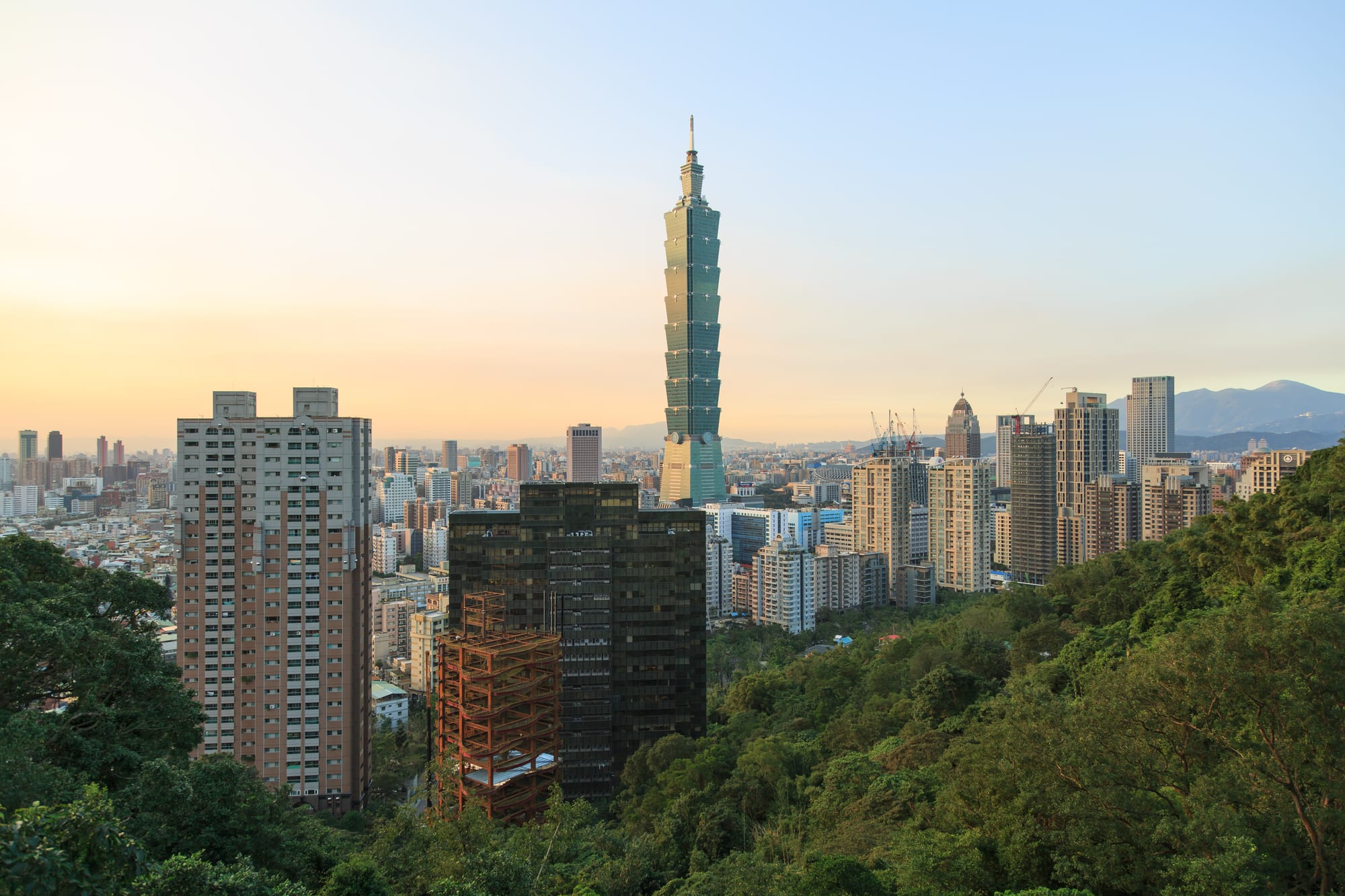 A tall skyscraper with distinctive segmented bamboo-like design rising above a city