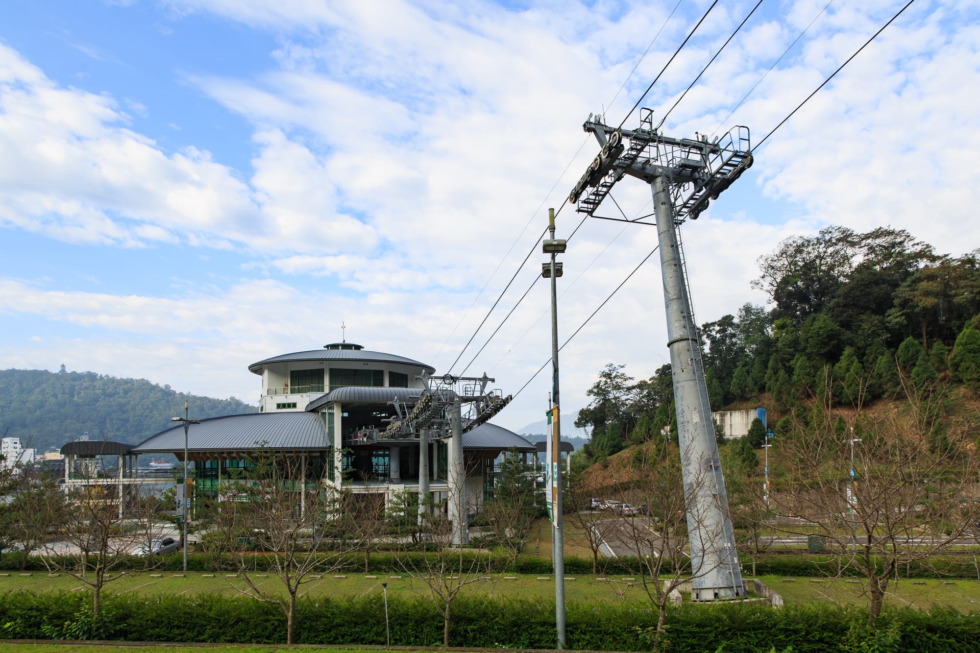 A cable car crossing above a large lake surrounded by forested mountains