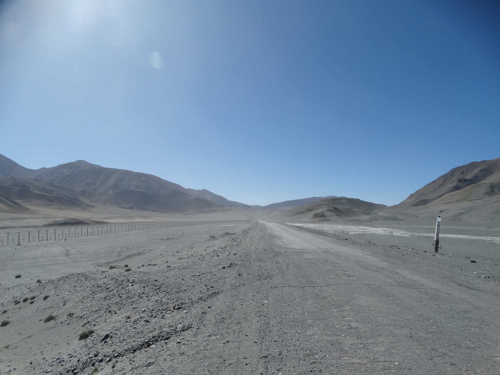 A remote high-altitude road with mountains in the distance