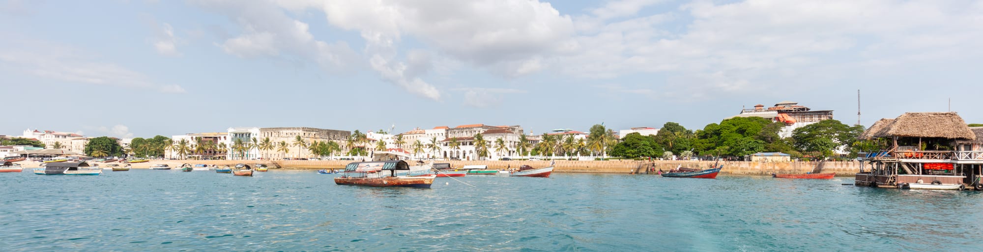 A historic waterfront town with dhows and old buildings