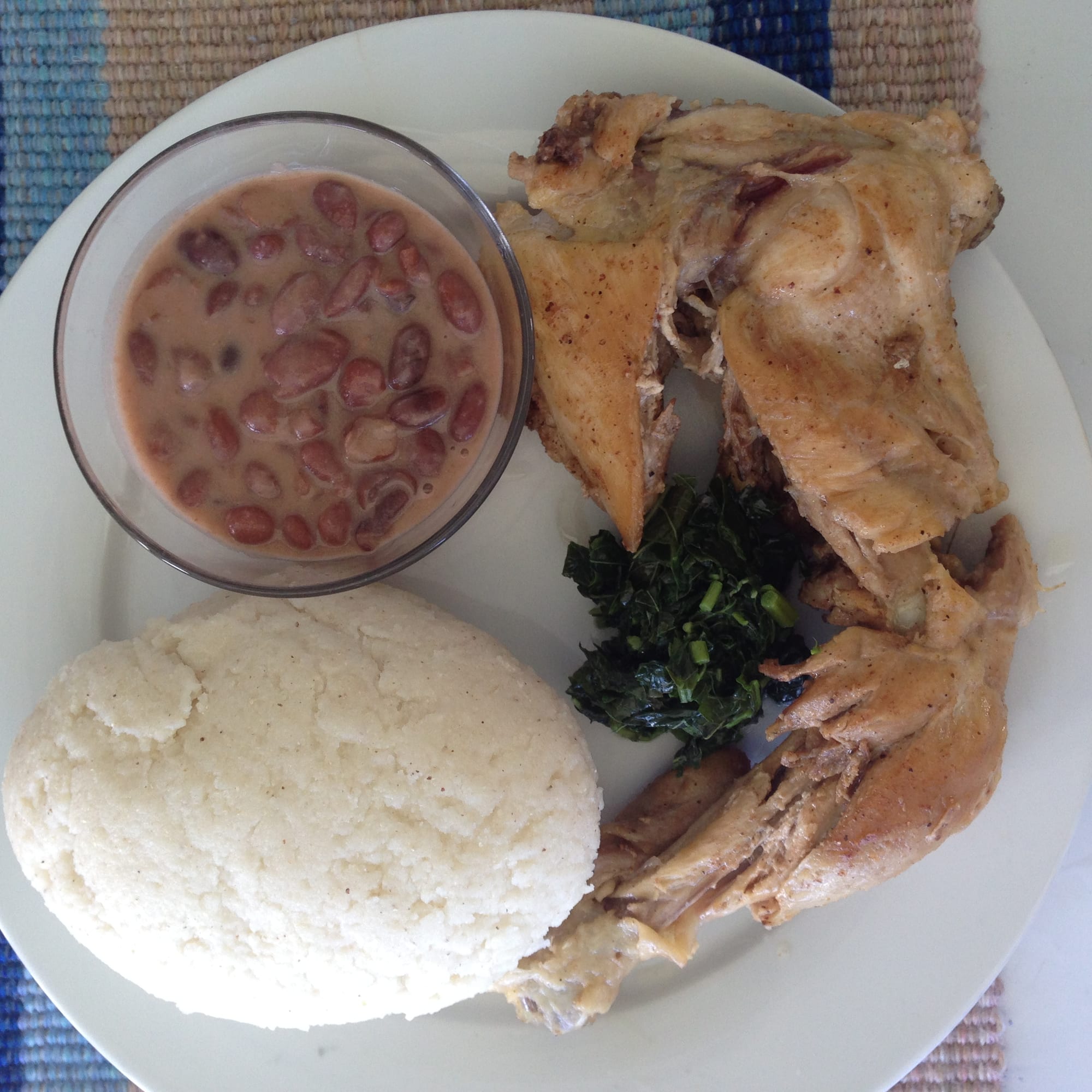 A plate of stiff maize porridge with beans and chicken