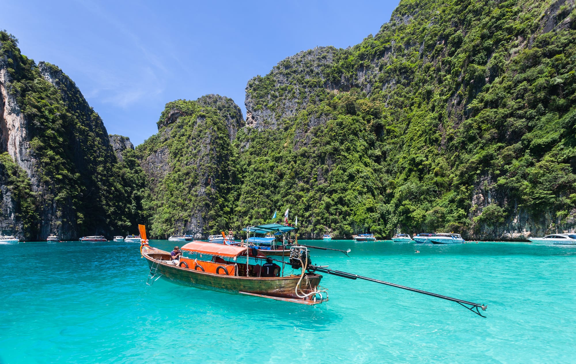 Steep limestone cliffs rising from turquoise water around a small bay