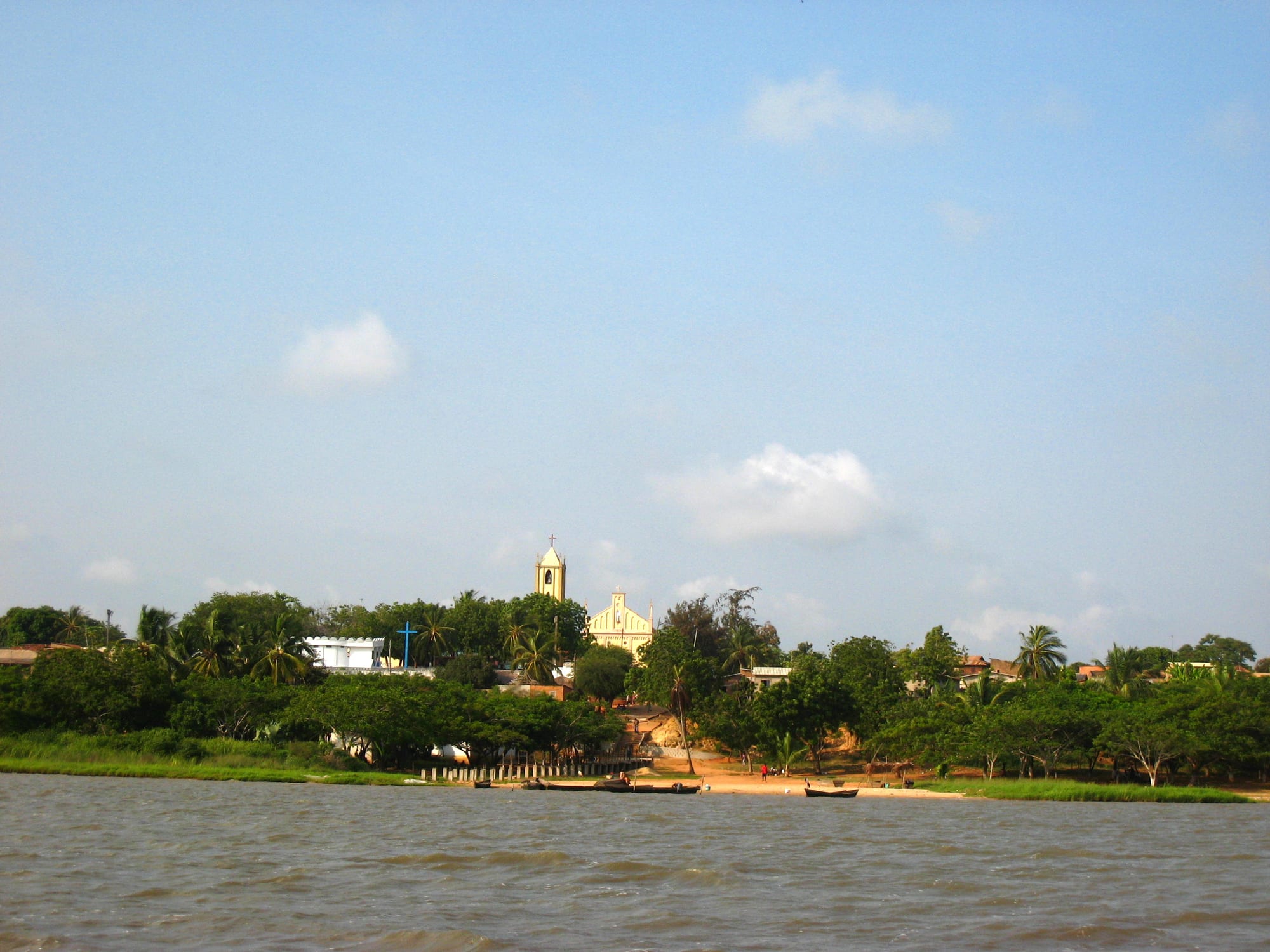 A lakeside town with a church visible among the trees