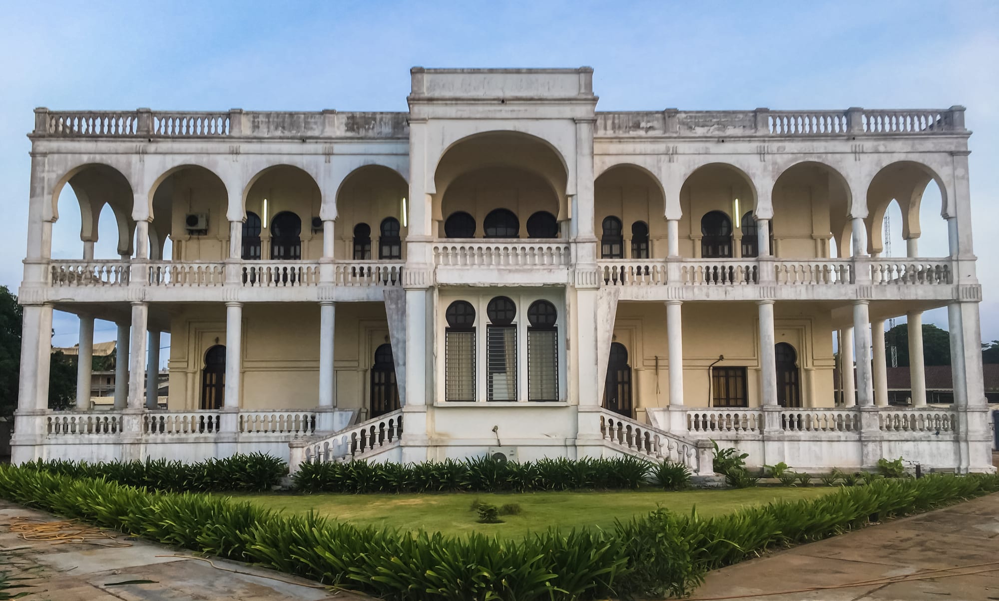 A weathered German colonial-era building with arched arcades and shuttered windows in Lomé