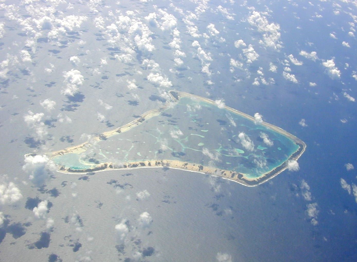 An aerial view of a coral atoll with a lagoon and scattered islets