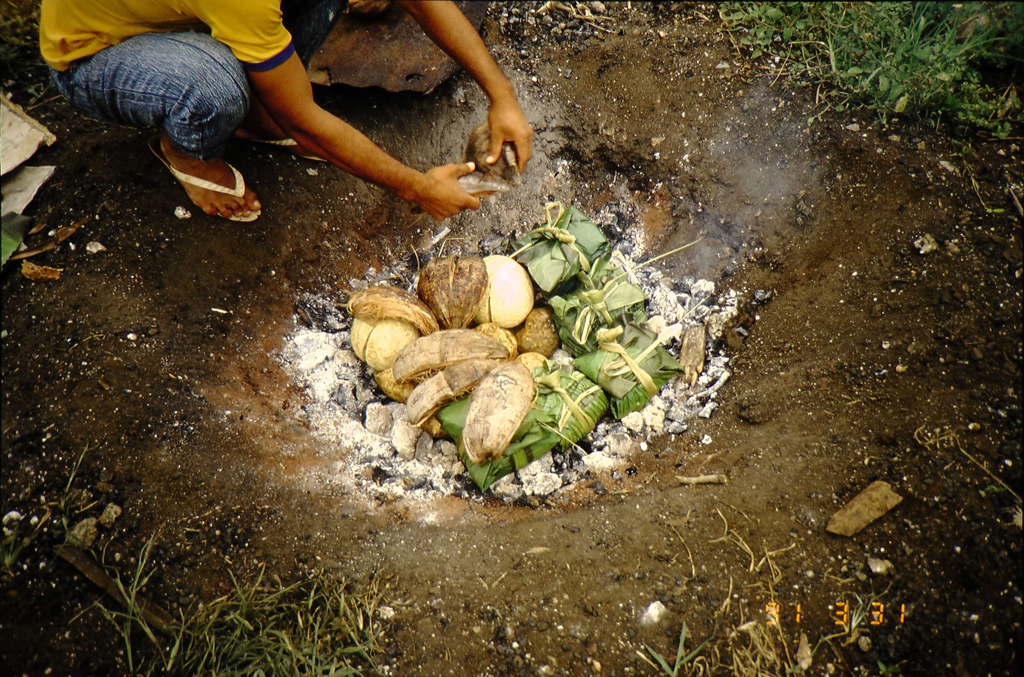 A traditional earth oven with heated stones
