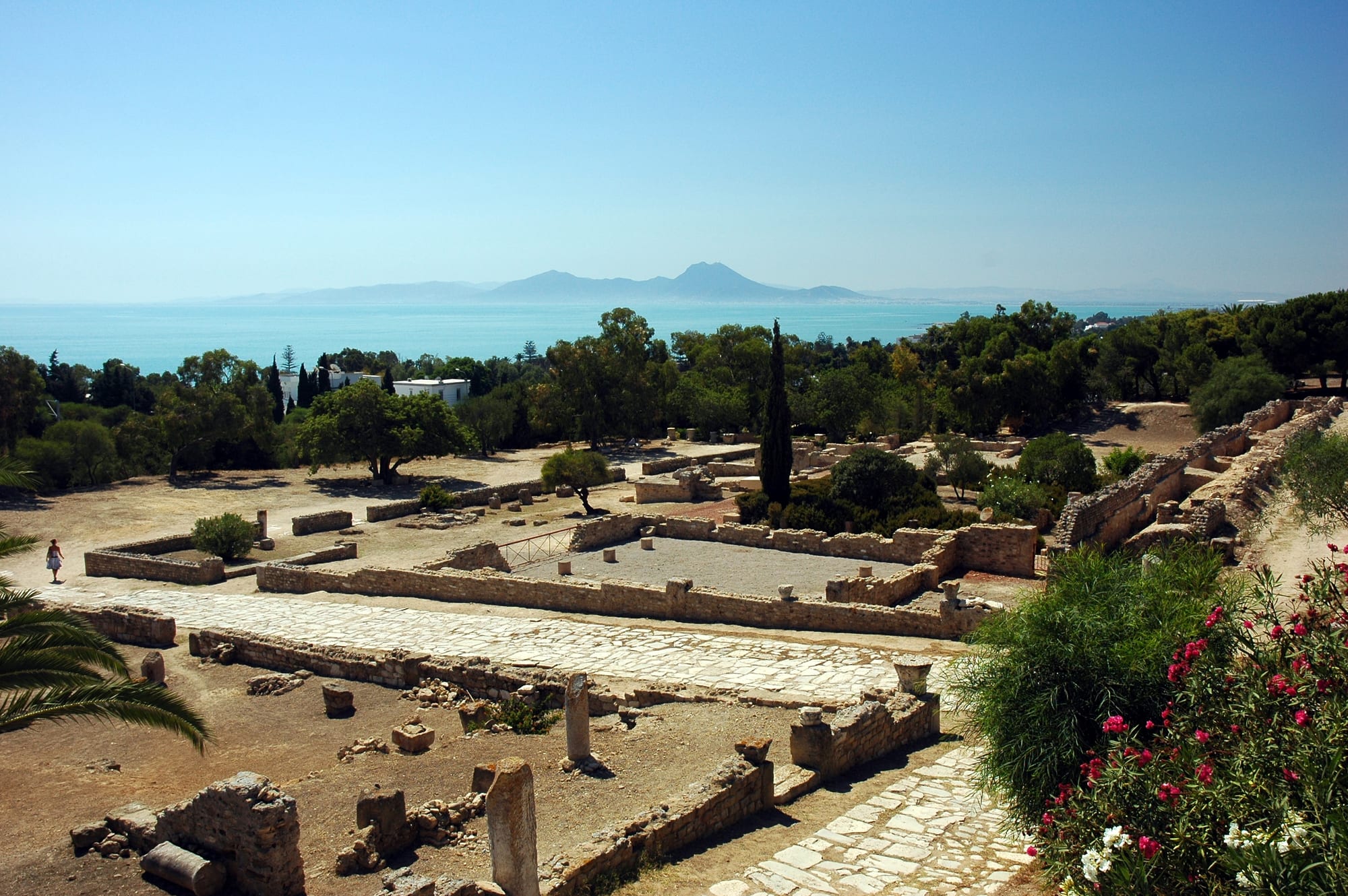 Ancient ruins on a hillside overlooking a turquoise gulf