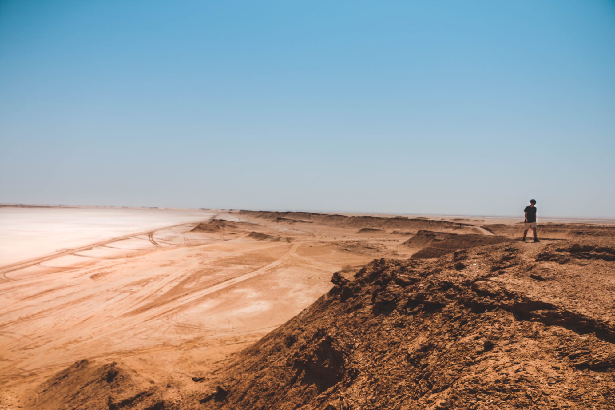 Vast golden sand dunes stretching to the horizon under intense heat haze