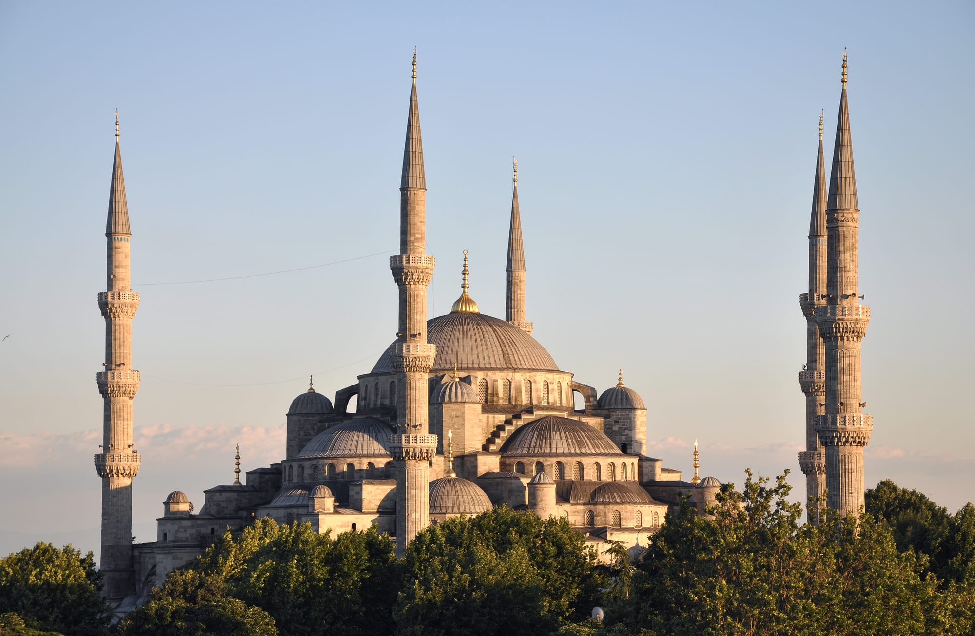 A grand mosque with cascading domes and six slender minarets