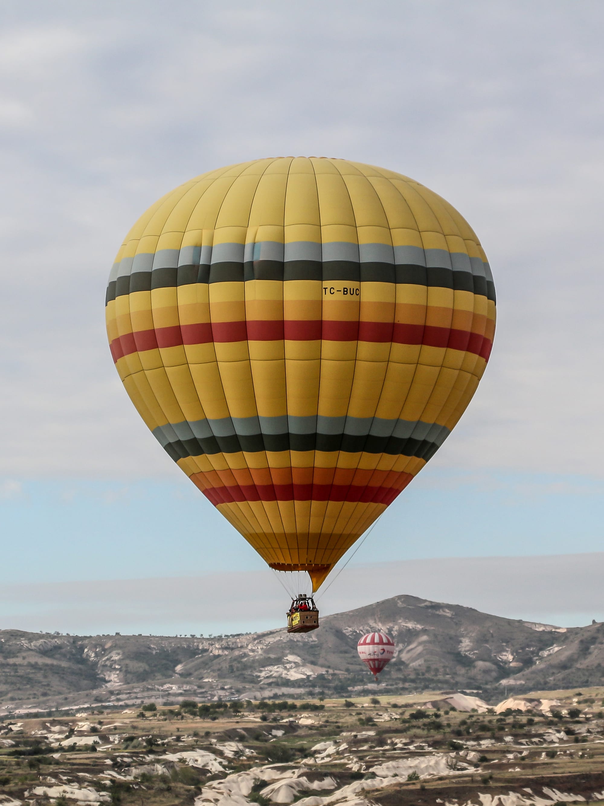 Colourful hot air balloons floating over a landscape of unusual rock formations