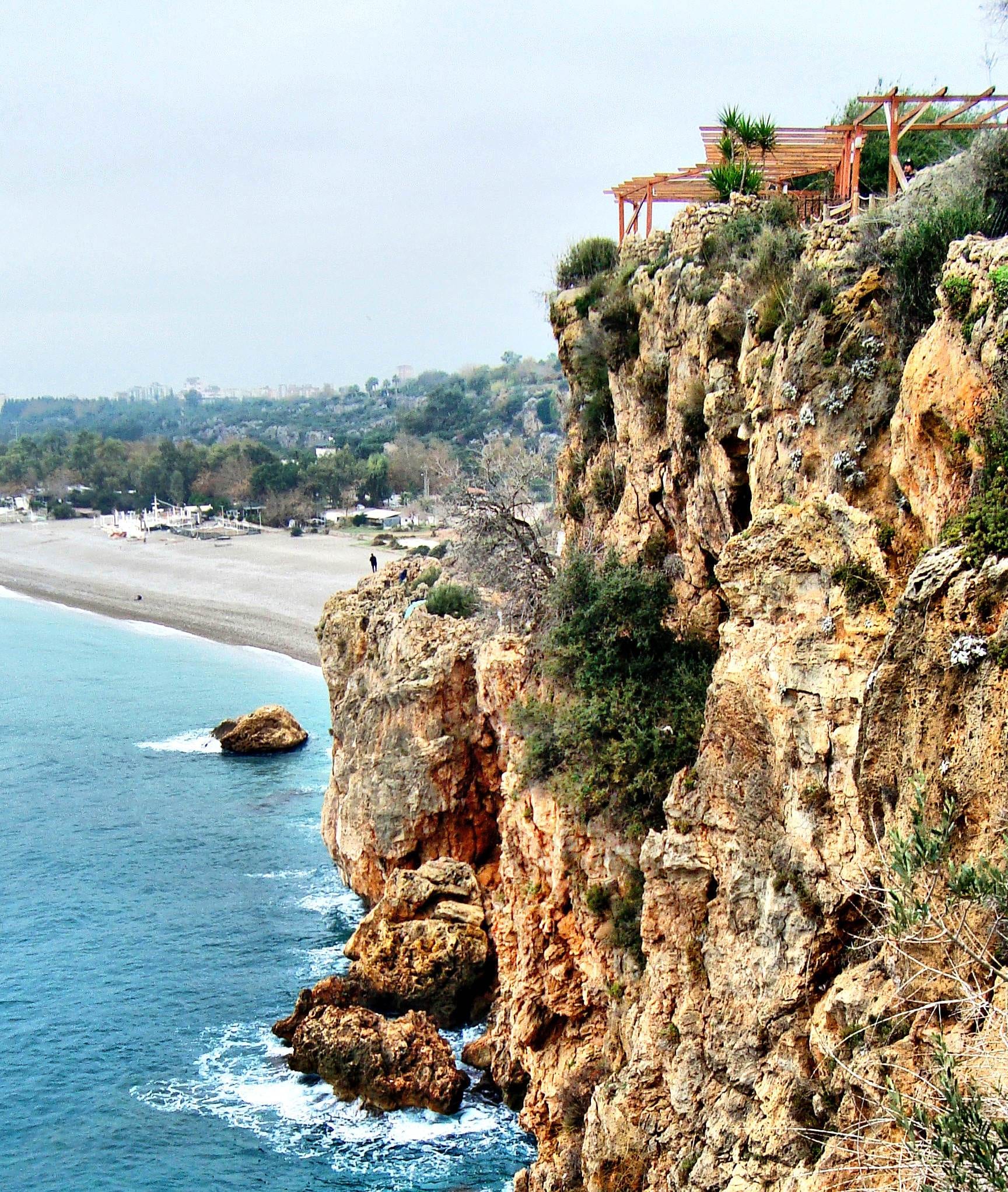 Sheer limestone cliffs dropping to a beach and turquoise Mediterranean sea