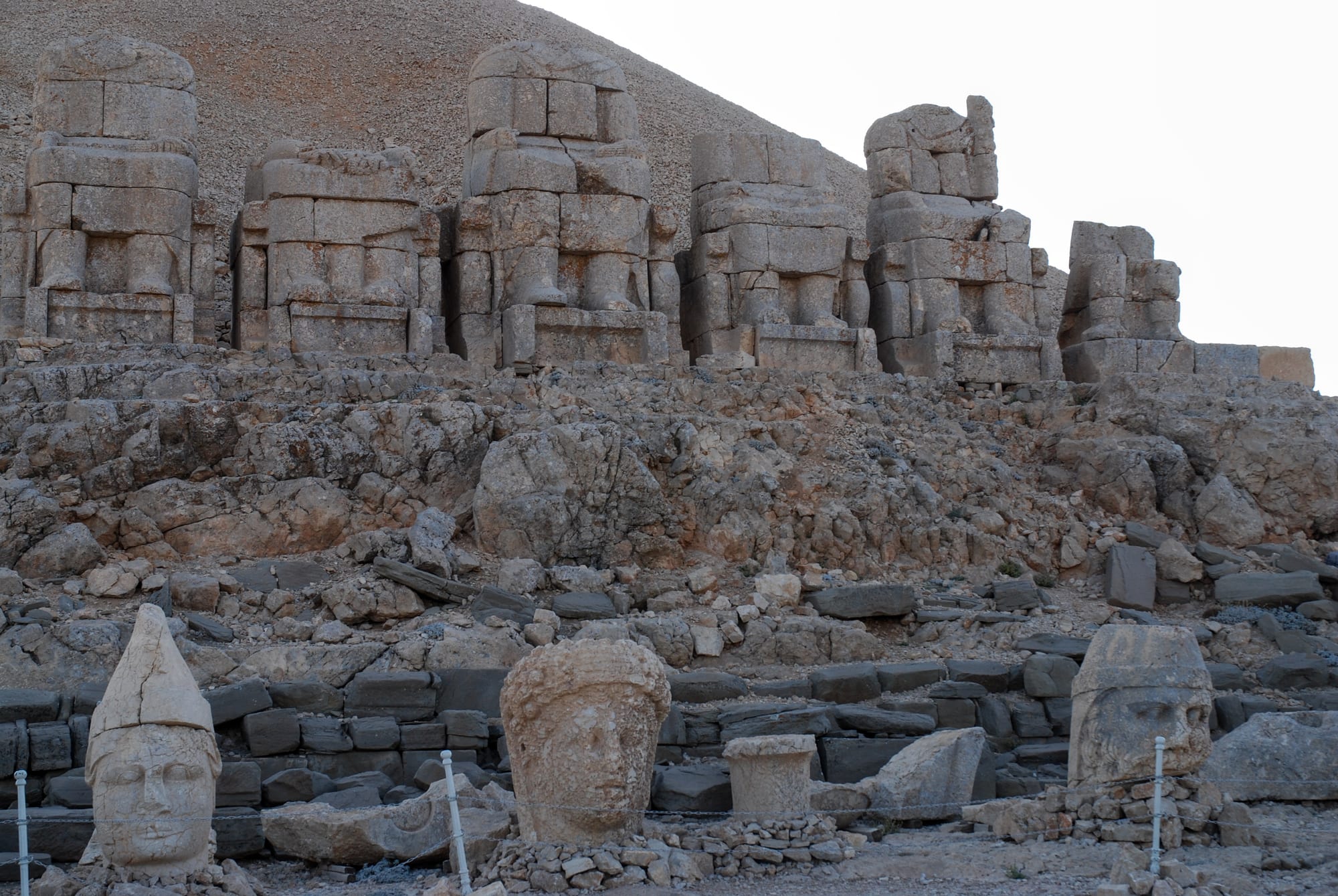Giant ancient stone heads lined up on a mountainside