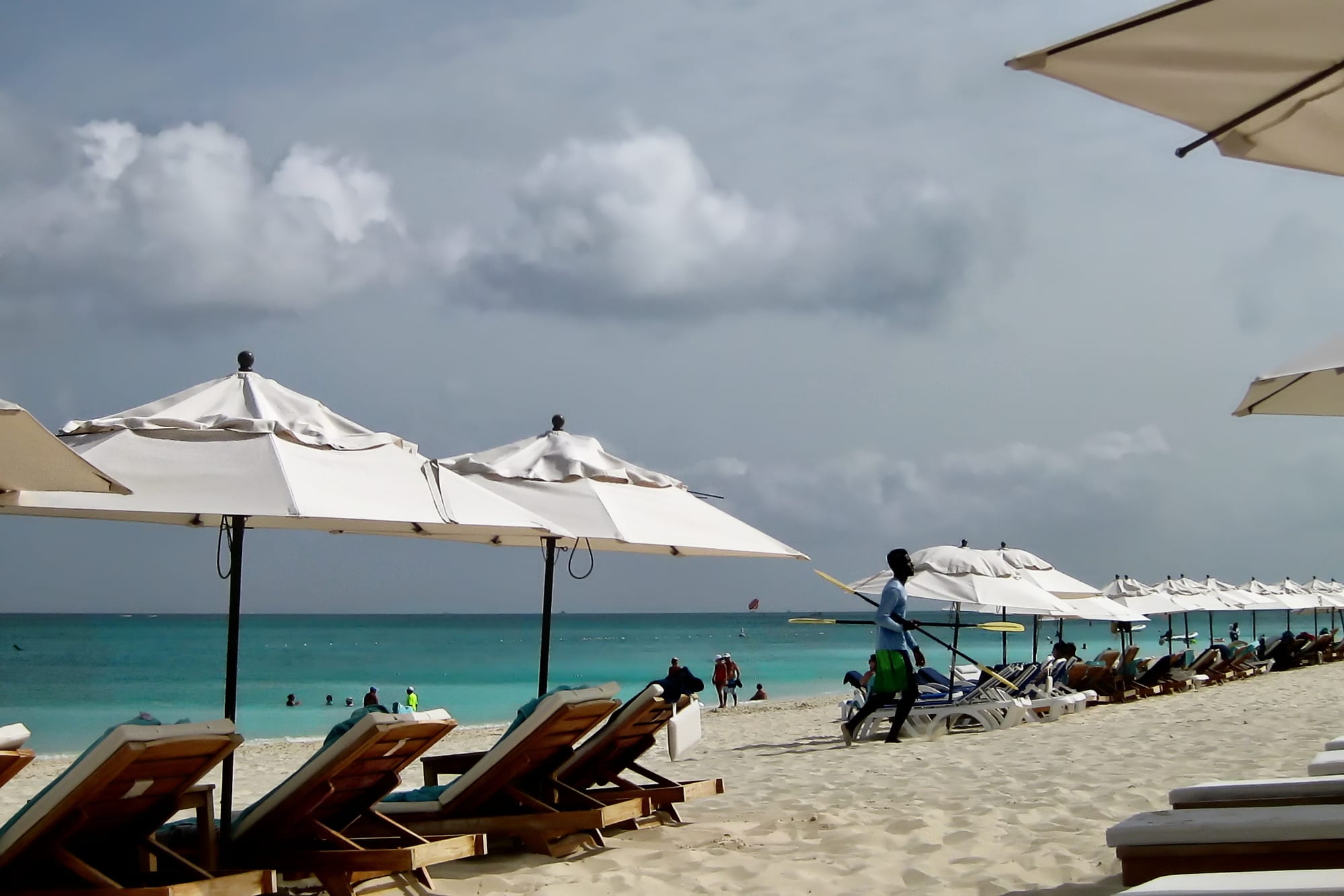 A wide beach with resorts along a calm turquoise bay