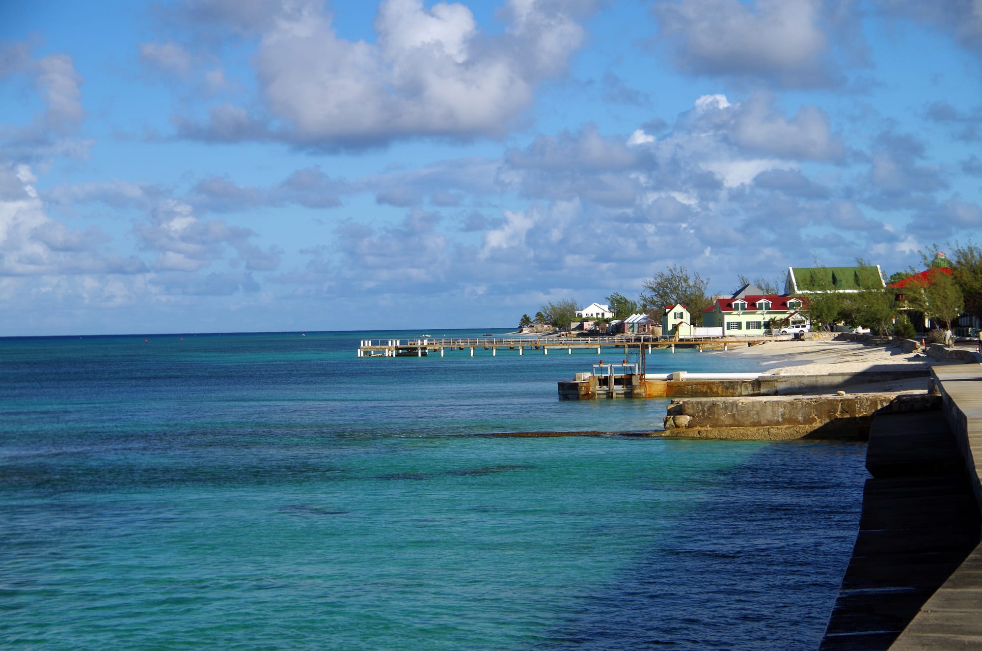 A quiet coastal street with colonial-era buildings along a beach