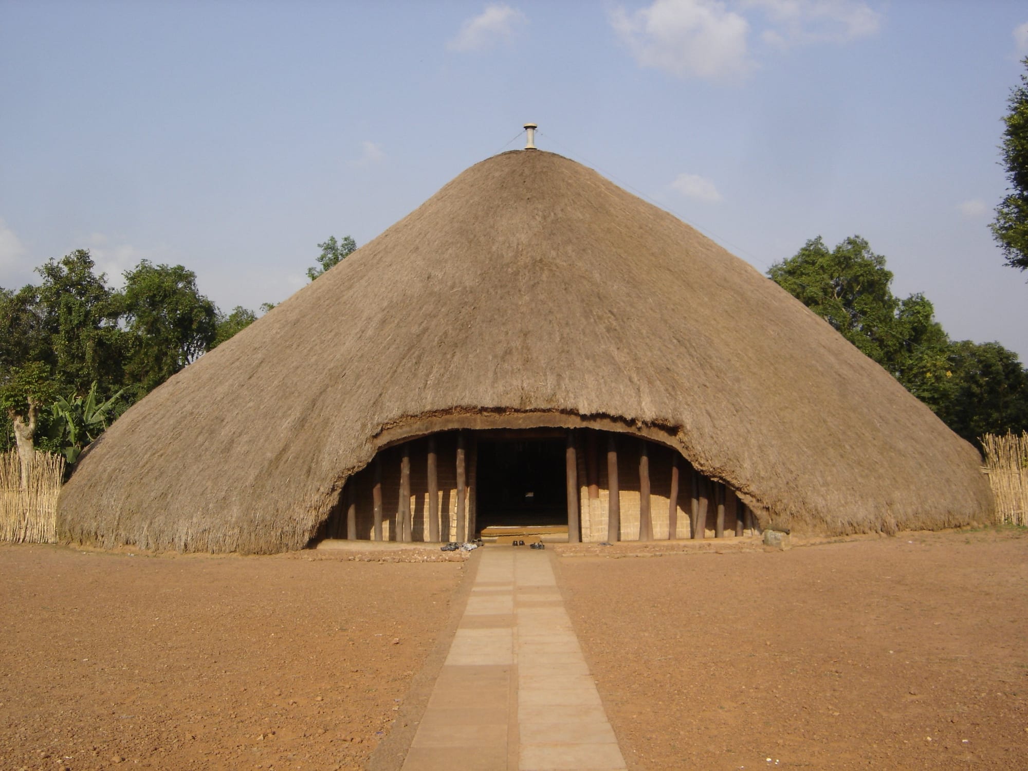 A large traditional thatched-roof building housing royal tombs