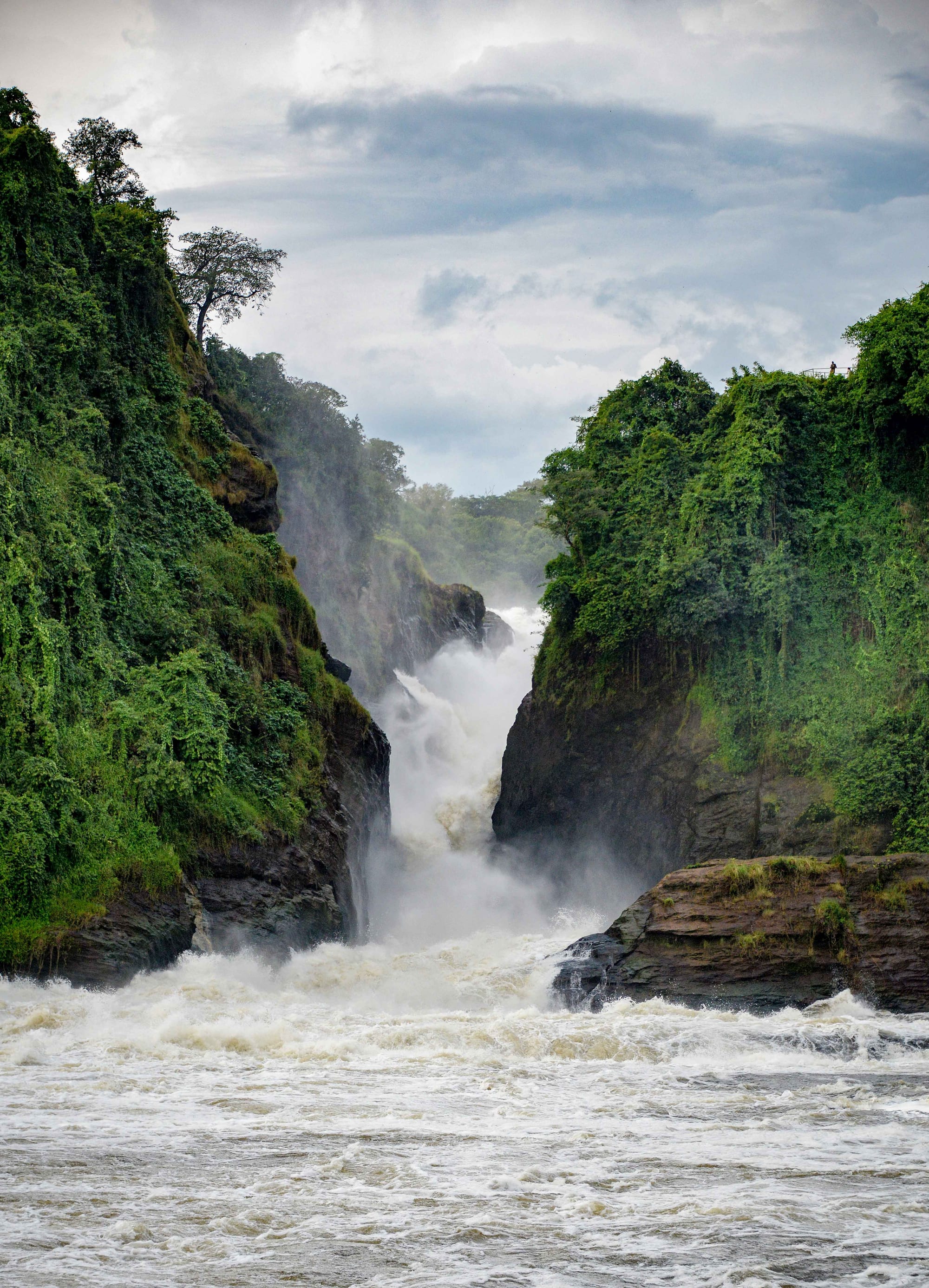 A powerful waterfall forcing a wide river through a narrow rocky gap