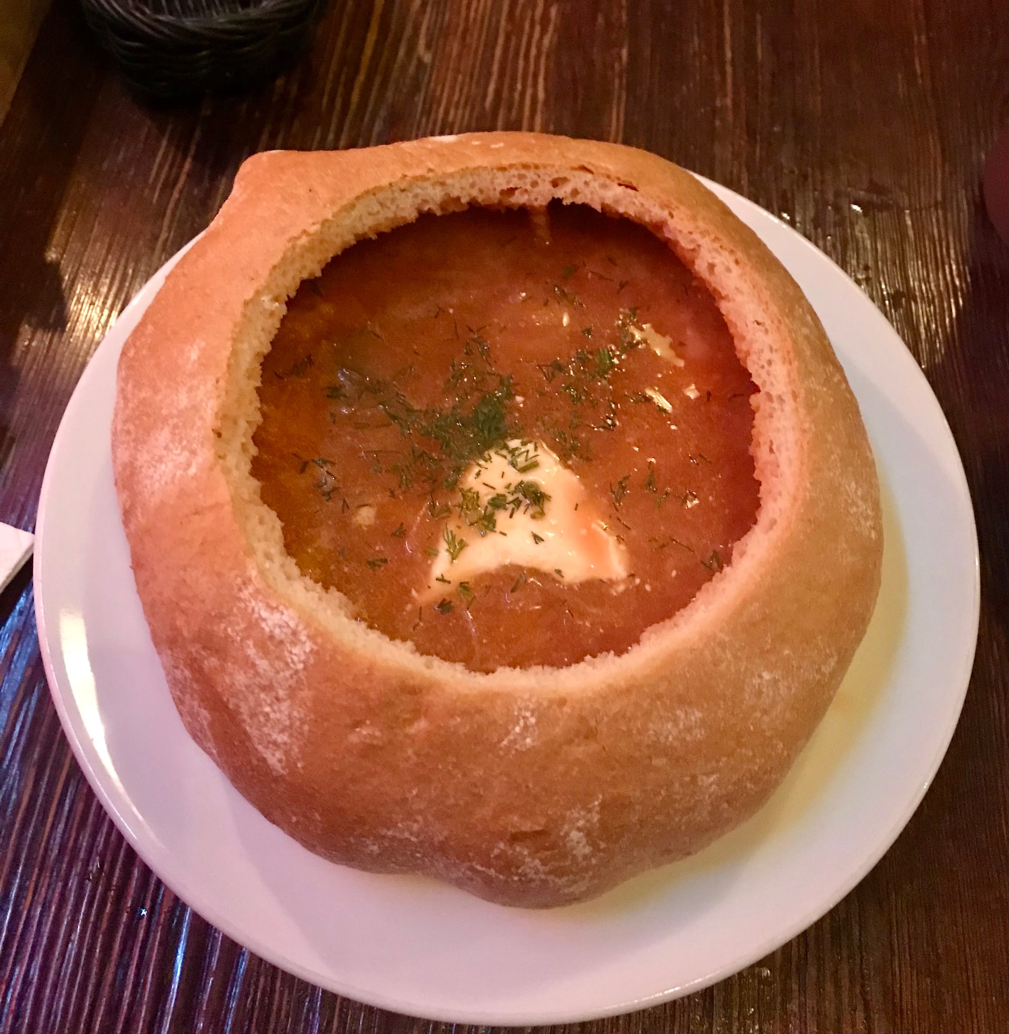 Red soup served inside a bread bowl