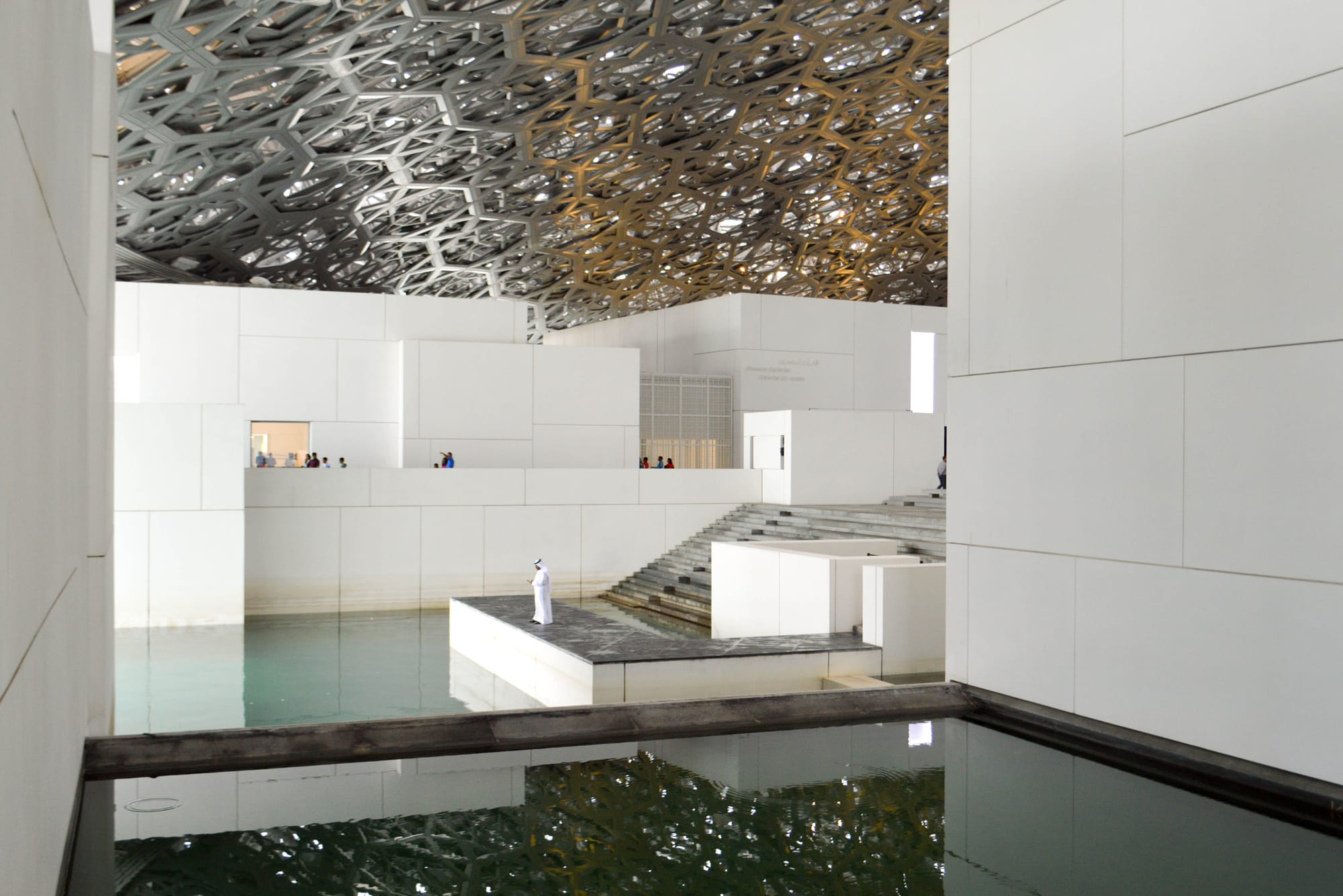 A museum building with an intricate perforated dome casting patterned light below
