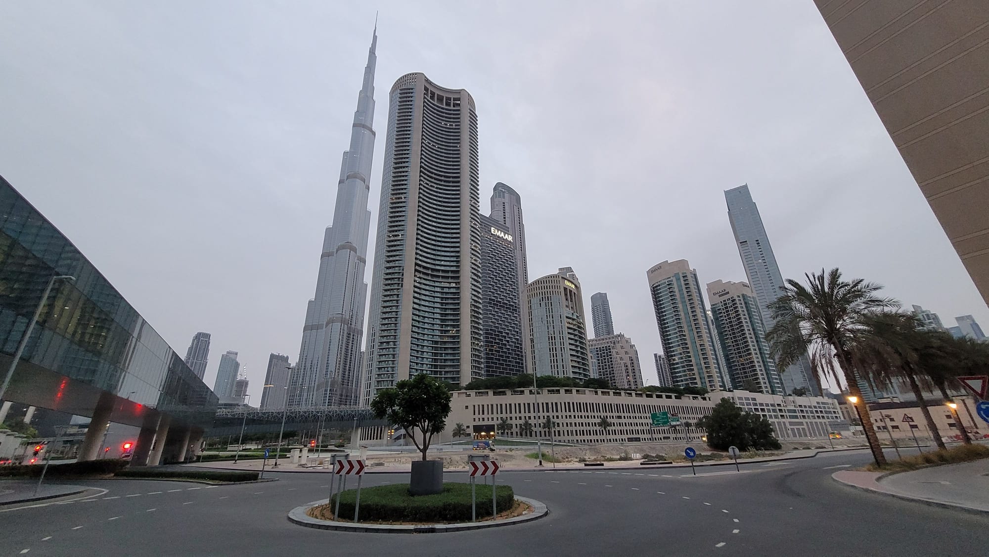 A towering skyscraper rising above the city, seen from outside a metro station