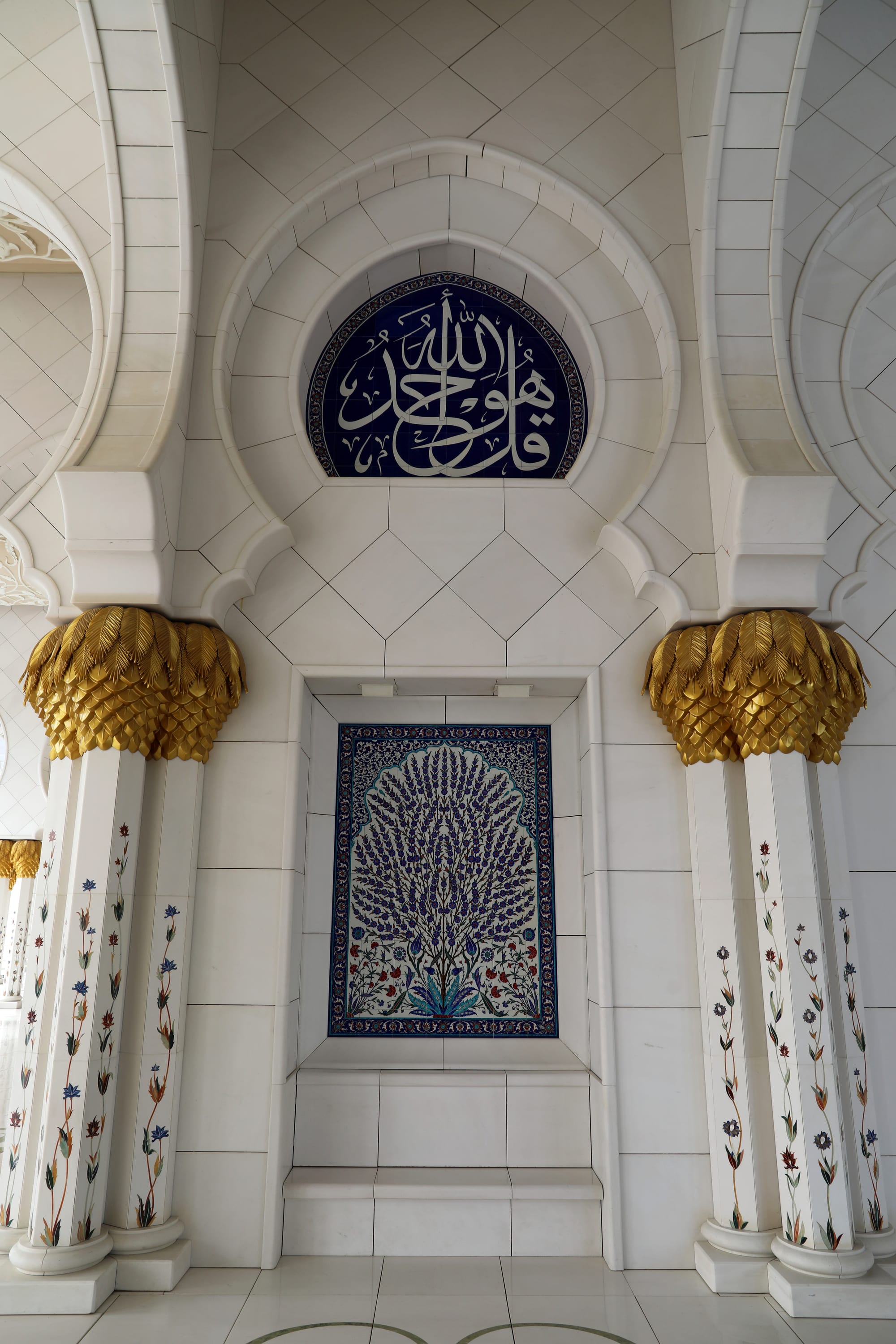 The arcaded white marble courtyard of the Sheikh Zayed Grand Mosque in Abu Dhabi with reflecting pools