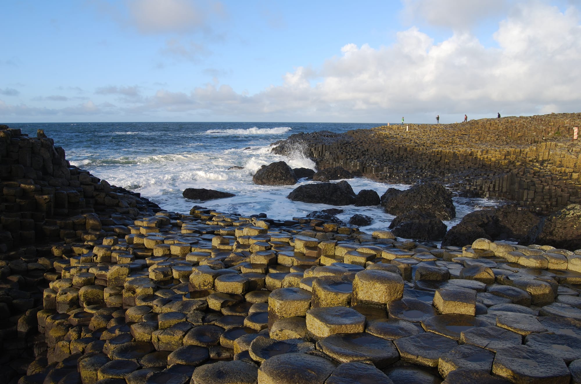 Thousands of naturally occurring hexagonal basalt columns along a coastline