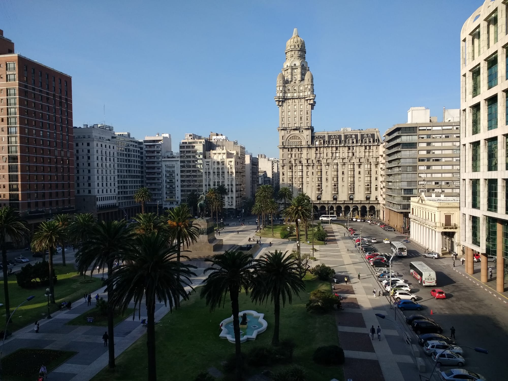 A broad plaza with a mounted statue and a tall early-20th-century tower block, the Palacio Salvo, in Montevideo