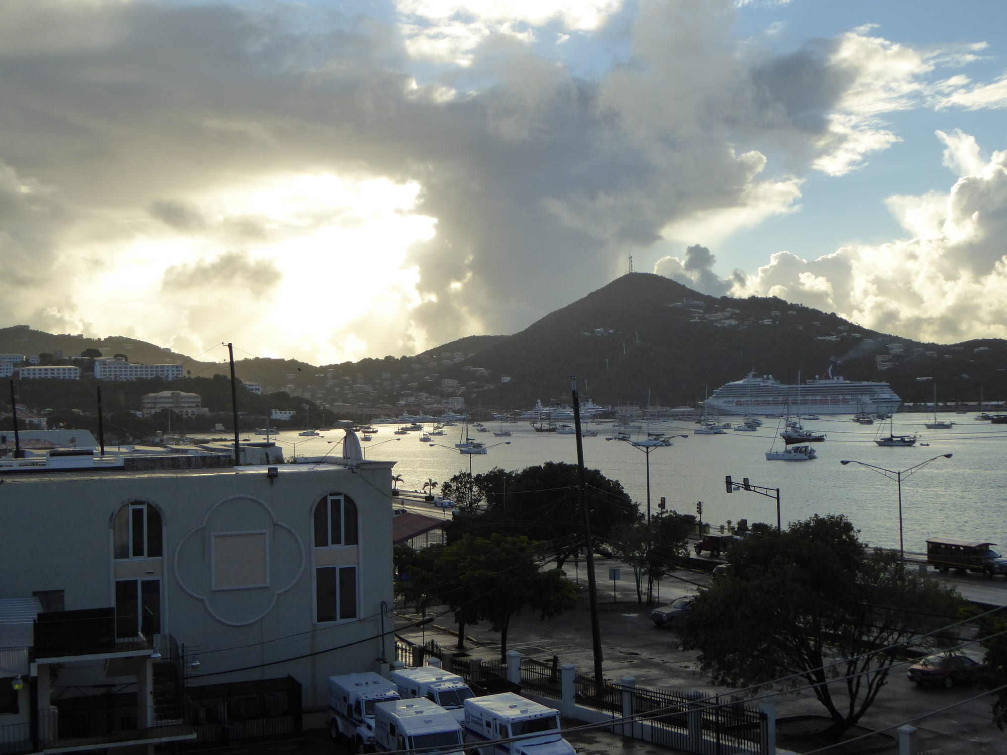 A view over a harbour town toward the sea with a cruise ship