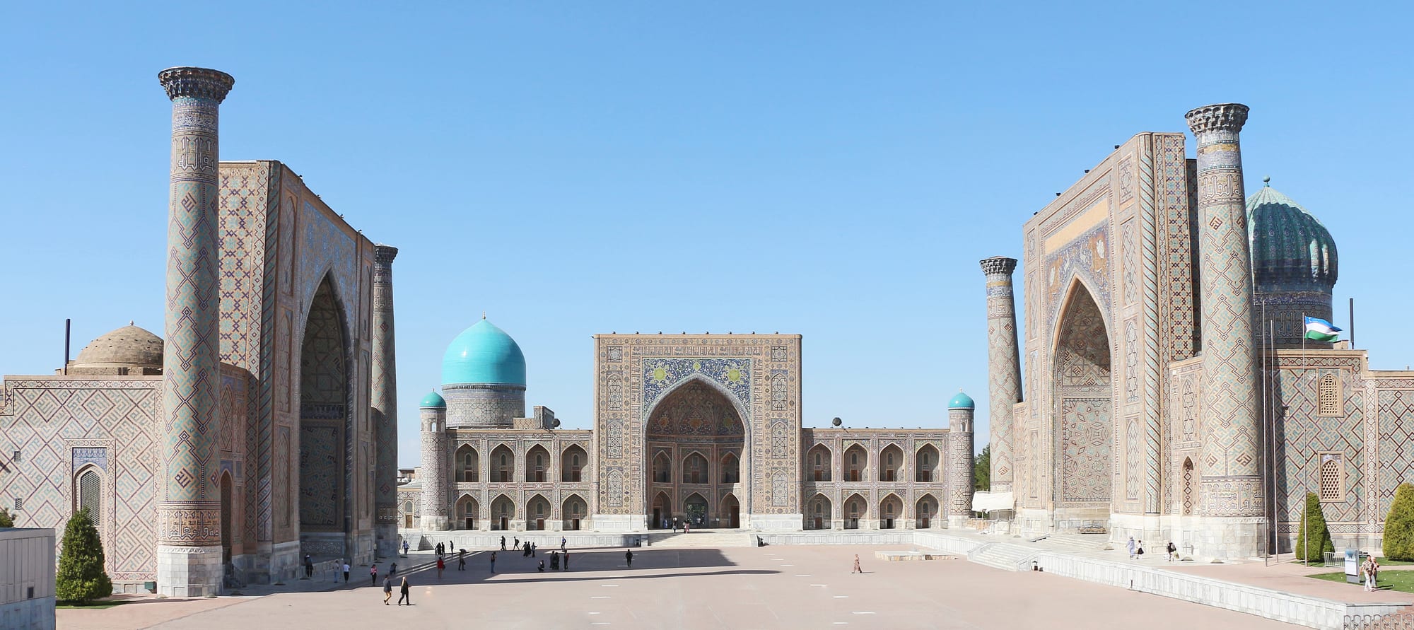 Ornate turquoise-tiled arches and domes of a grand Islamic building