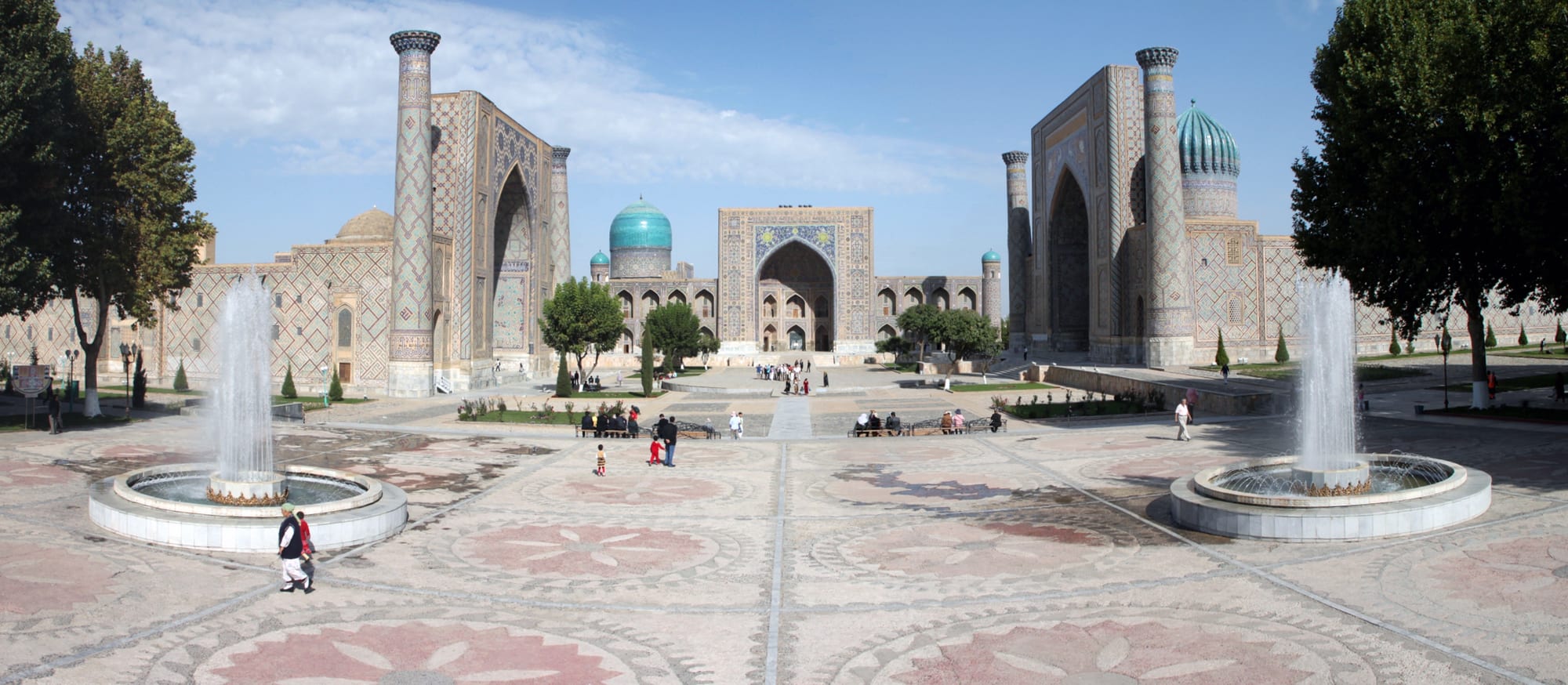 Three grand turquoise-tiled Islamic madrasas facing a central square