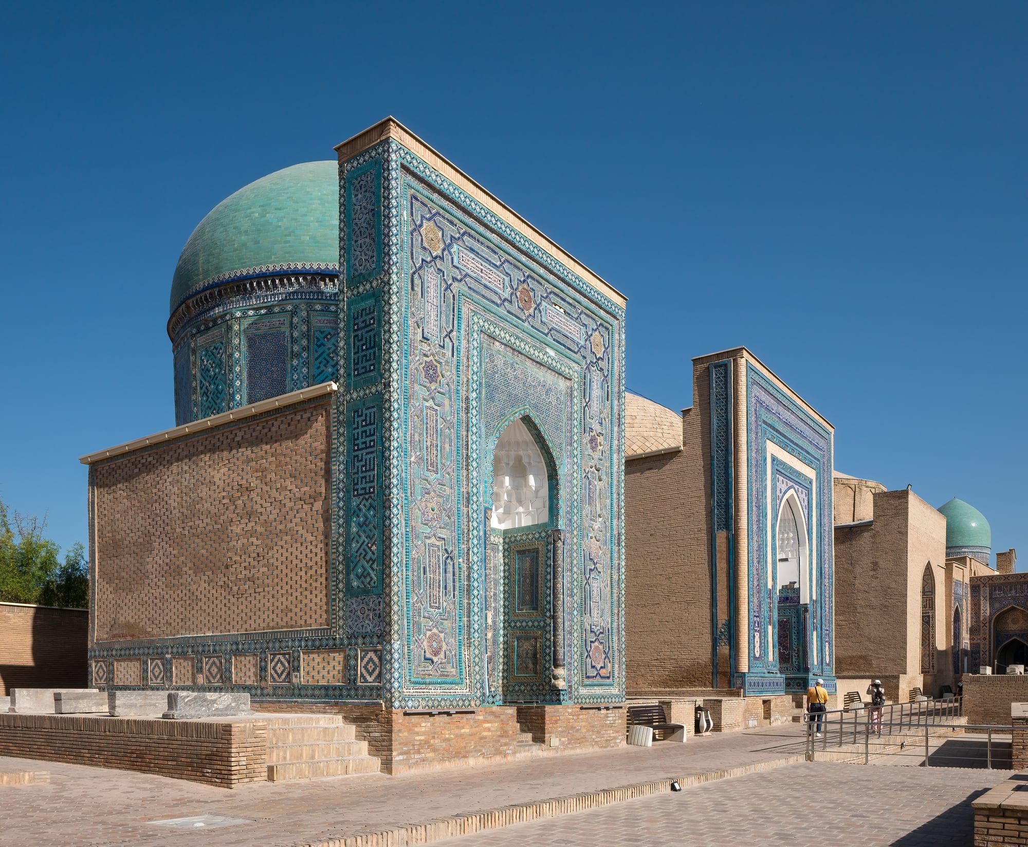 A corridor of ornately tiled mausoleum domes and archways