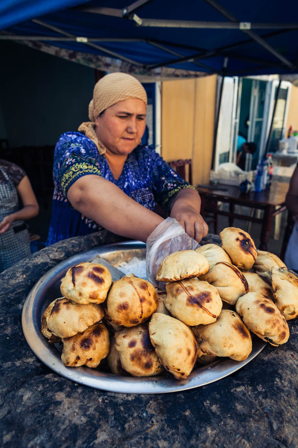 A baker preparing pastries in a traditional oven
