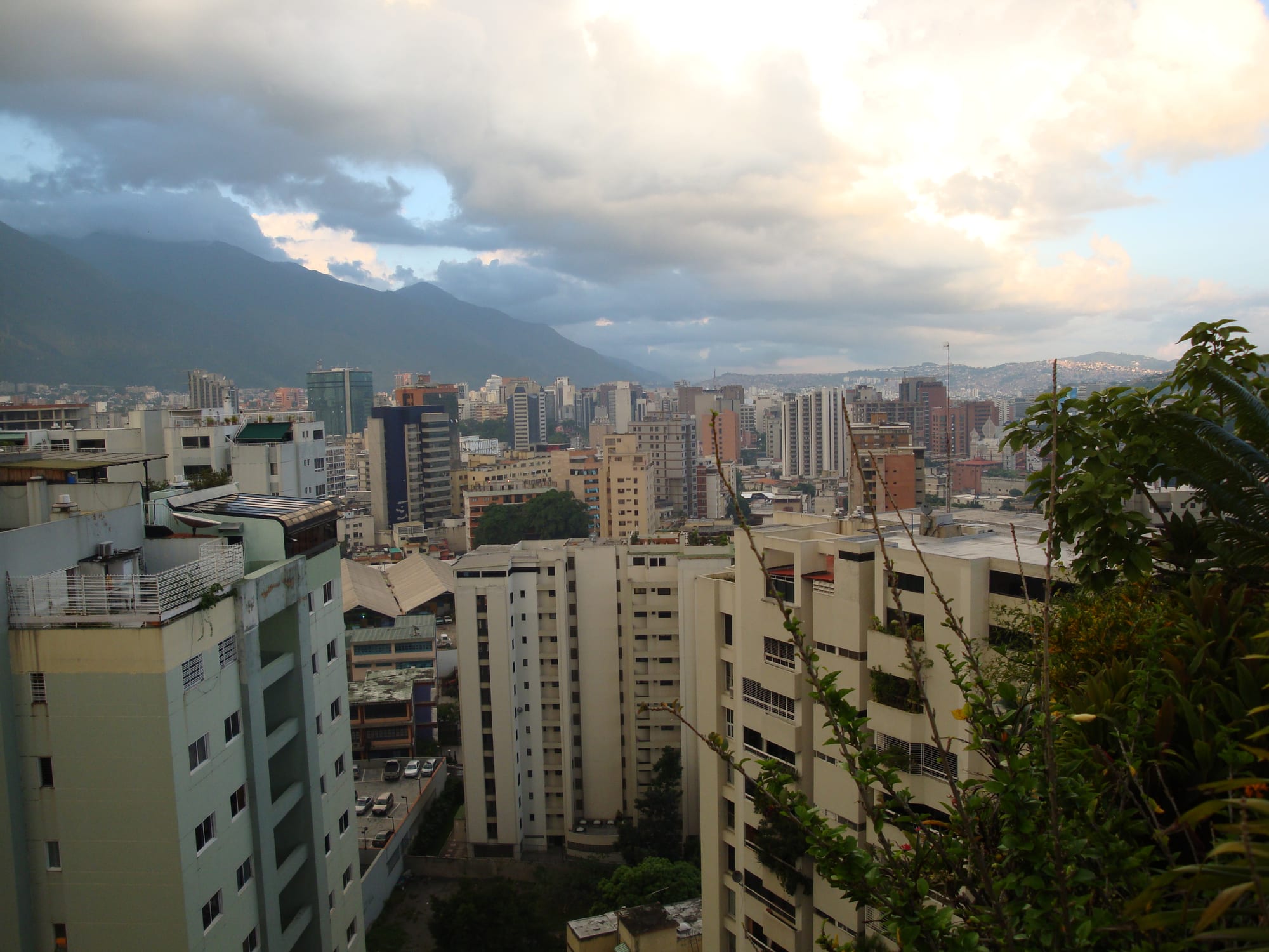 A city skyline of high-rise towers set beneath a mountain range