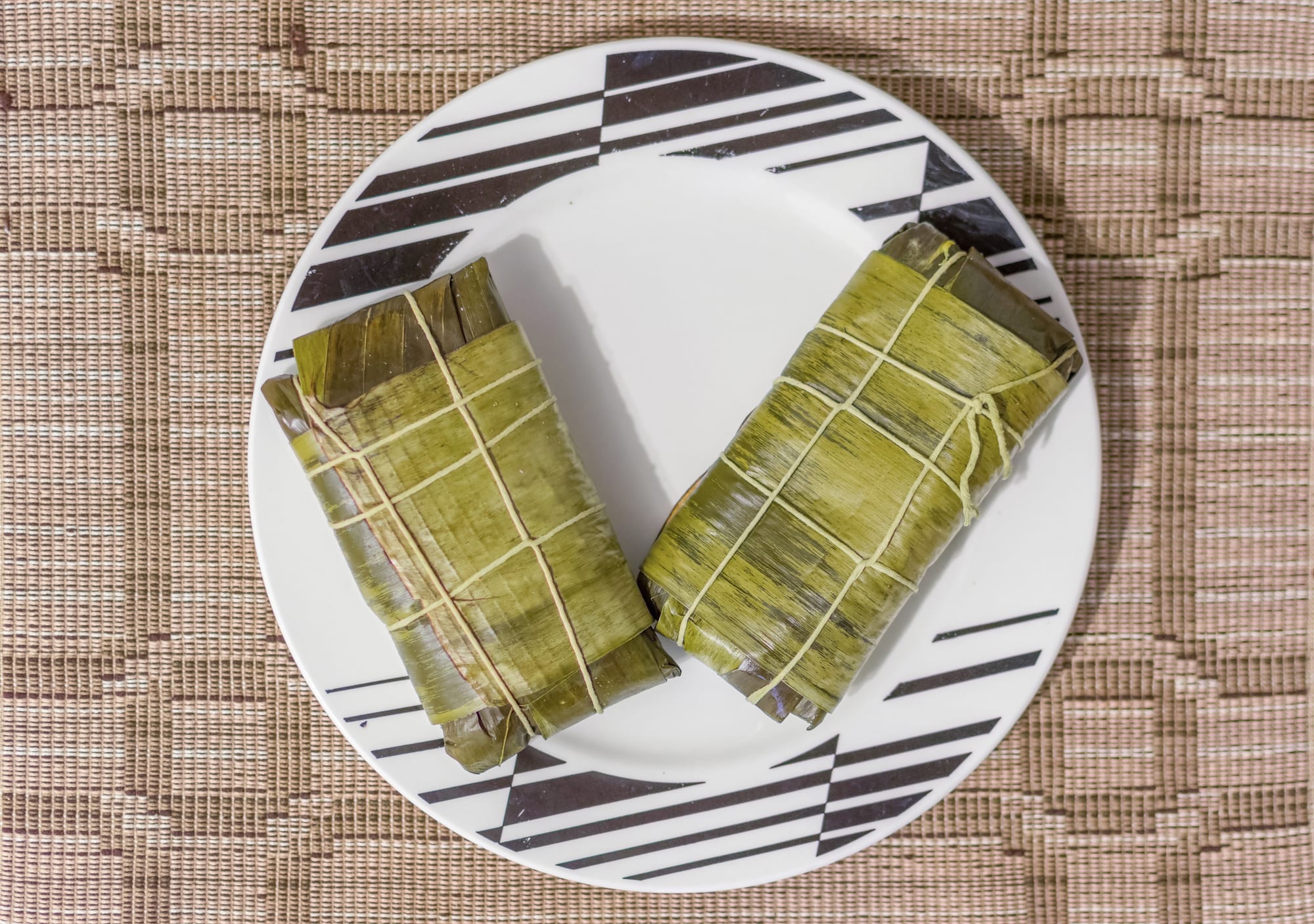 Cornmeal dough filled with stew, wrapped in banana leaf