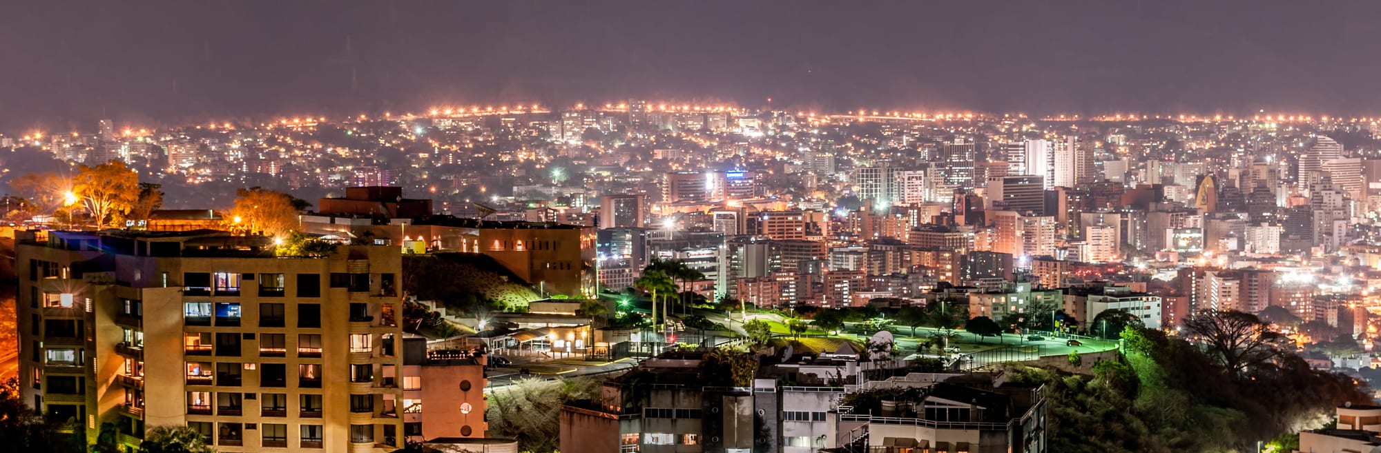 The lights of Caracas filling a long valley between dark mountain ridges at night
