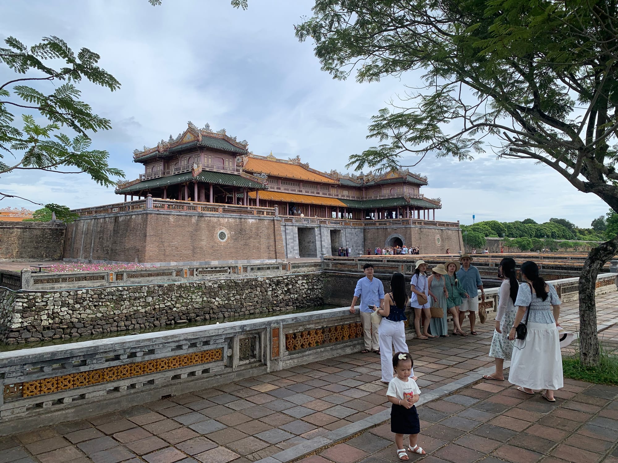 An ornate tiered gate with a moat, part of a walled imperial citadel