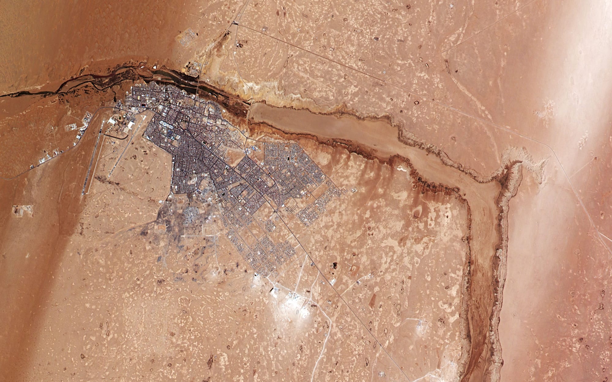 A satellite or aerial view of a desert city near the coast