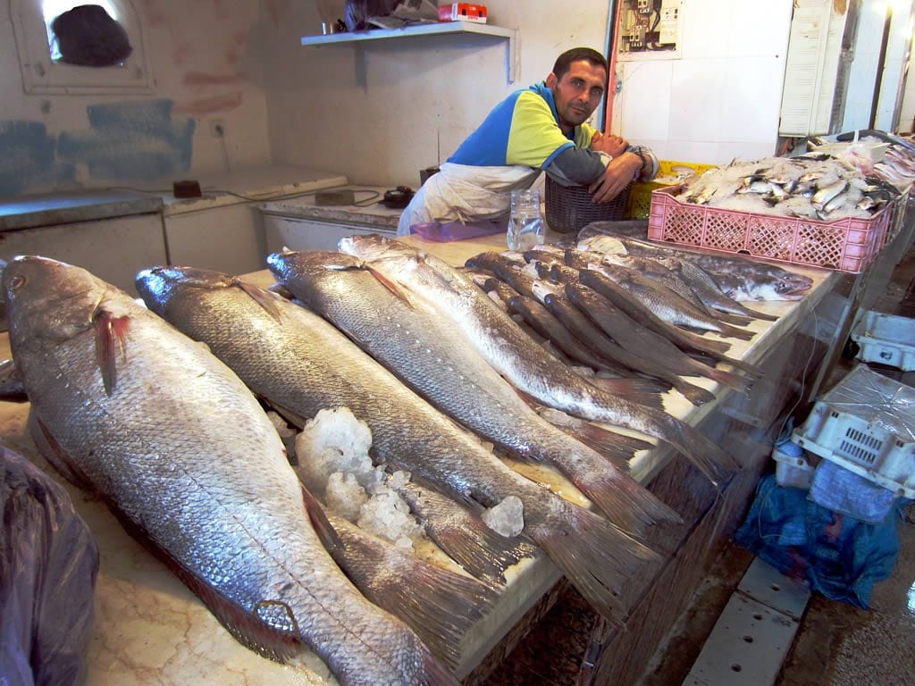 A vendor selling fish at a market stall