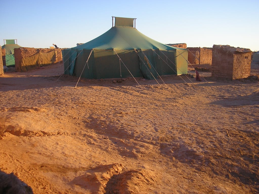 Rows of tents and mud-brick buildings in a Sahrawi refugee camp in the Algerian desert