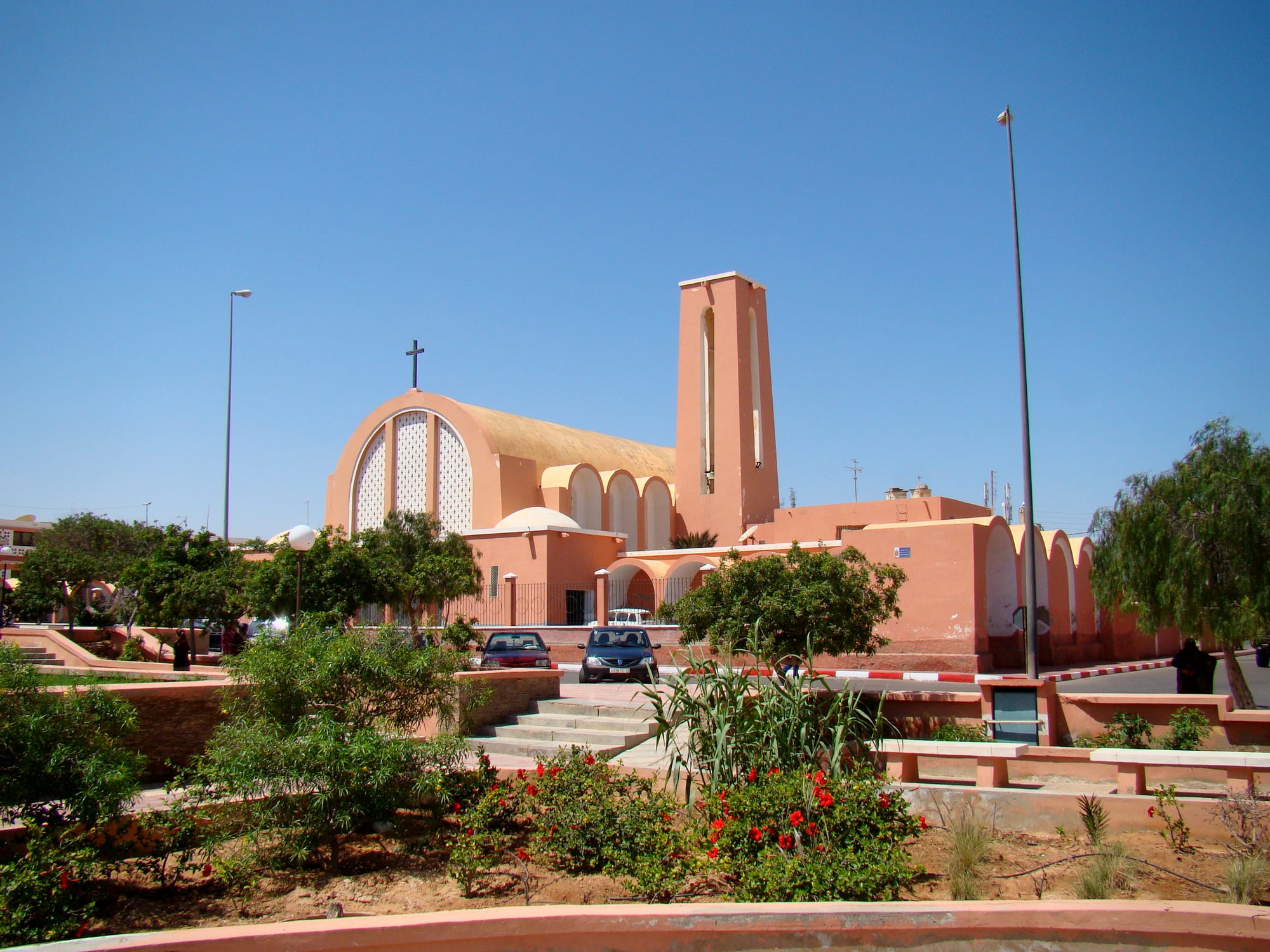 A plain white modernist Spanish colonial cathedral with a slender tower in Laayoune