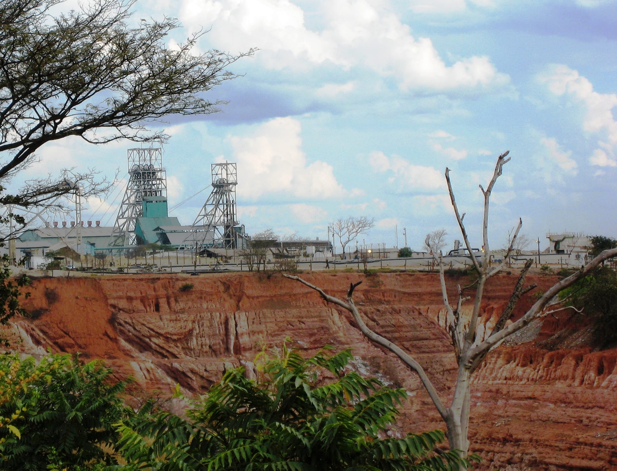 A tall steel mine headframe and winding gear towering over buildings on the Copperbelt at Kitwe