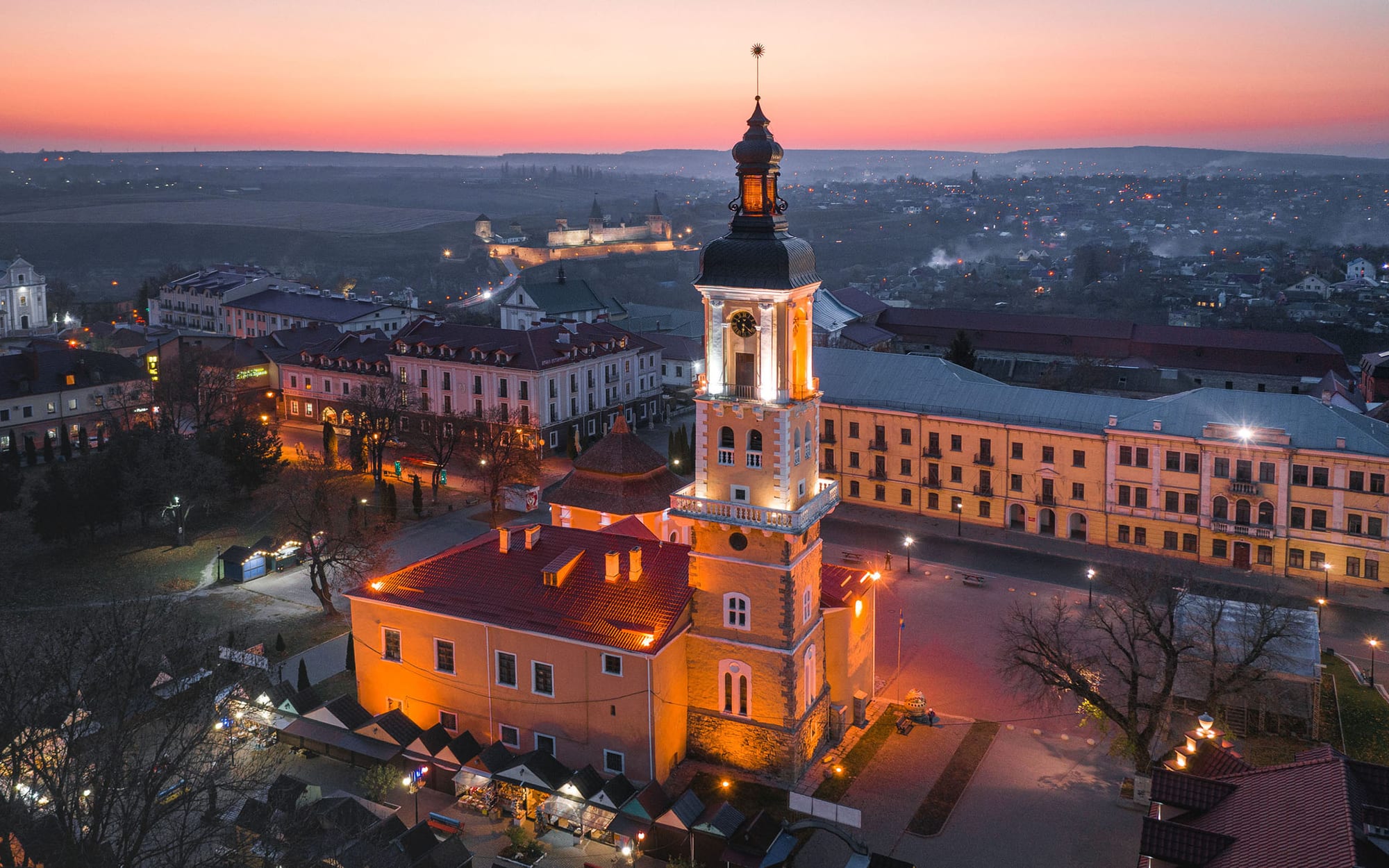 Aerial view of a town hall tower rising over an old market square