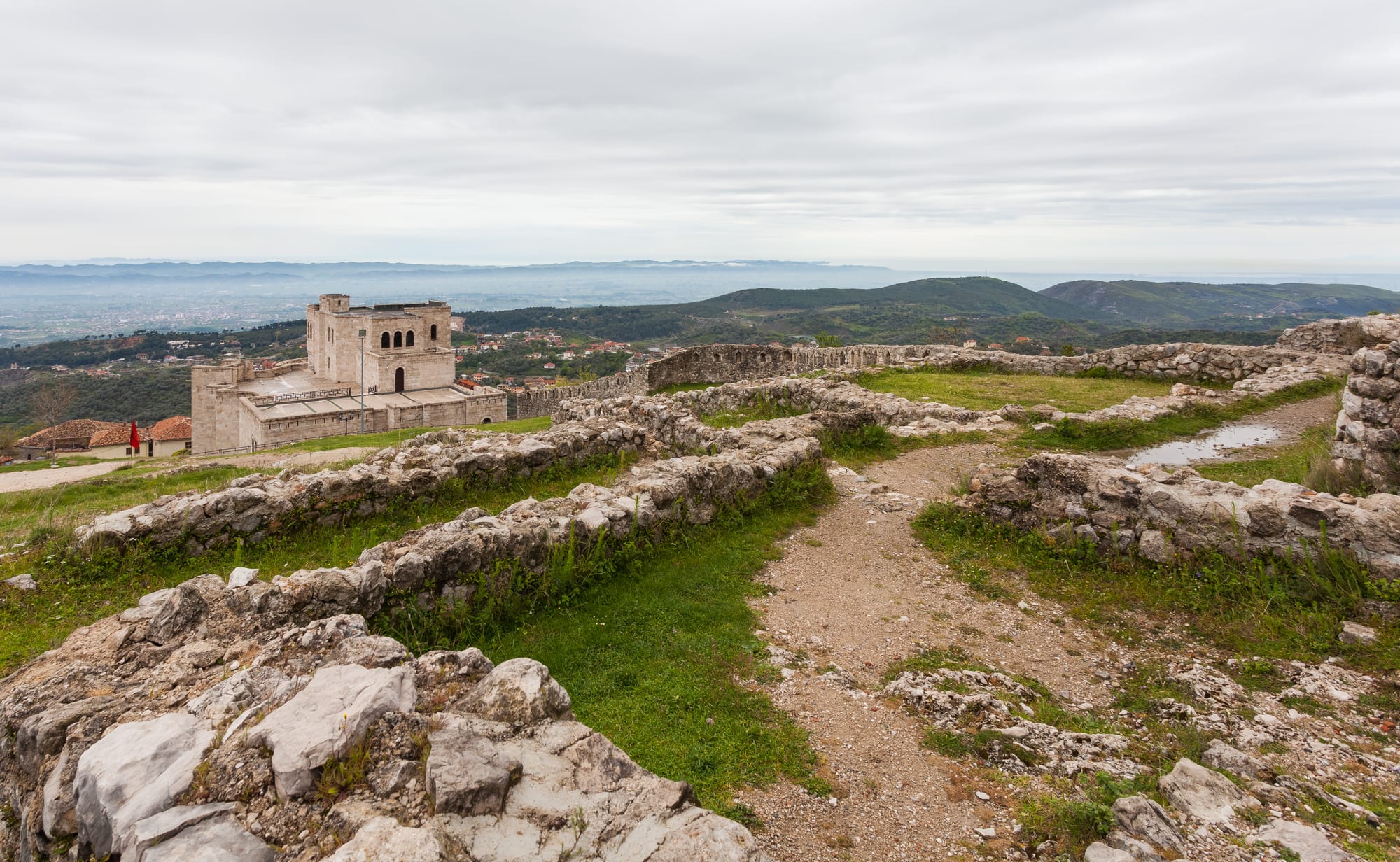 Ruined stone walls of Kruja Castle and the Skanderbeg Museum on their hilltop above the coastal plain