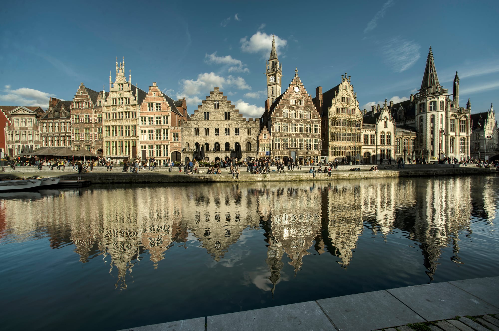 Gabled medieval guildhouses of the Graslei in Ghent reflected in the river Leie in evening light