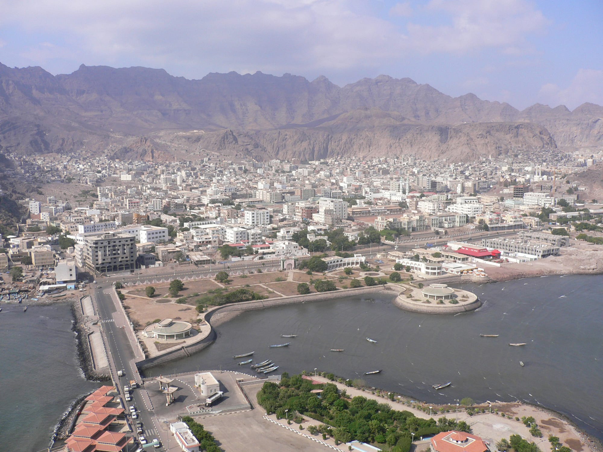 Aerial view of Crater's white buildings and a small harbour of fishing boats beneath a ring of bare brown volcanic ridges